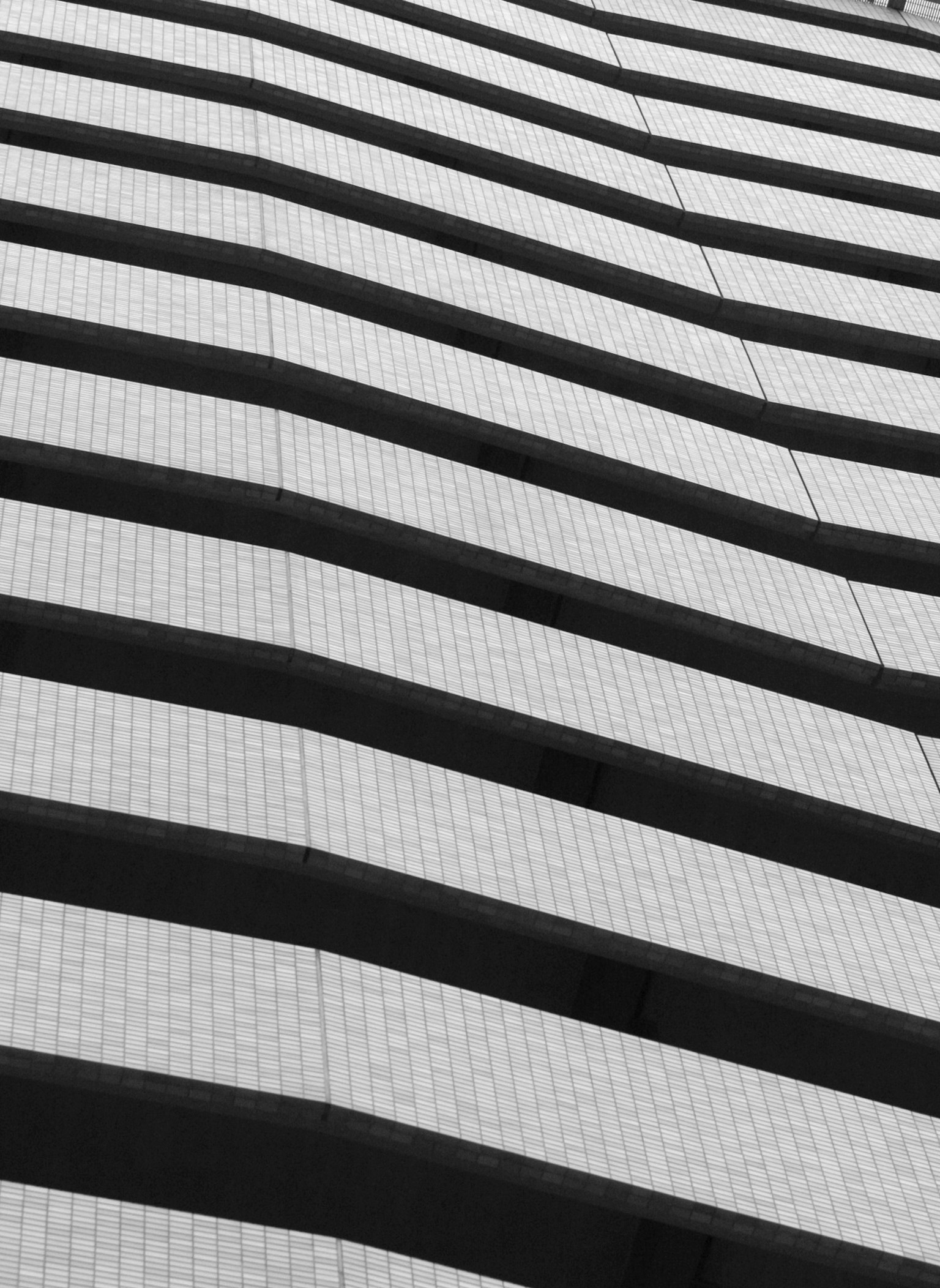 Façade de bâtiment moderne avec des bandes noires et blanches se chevauchant