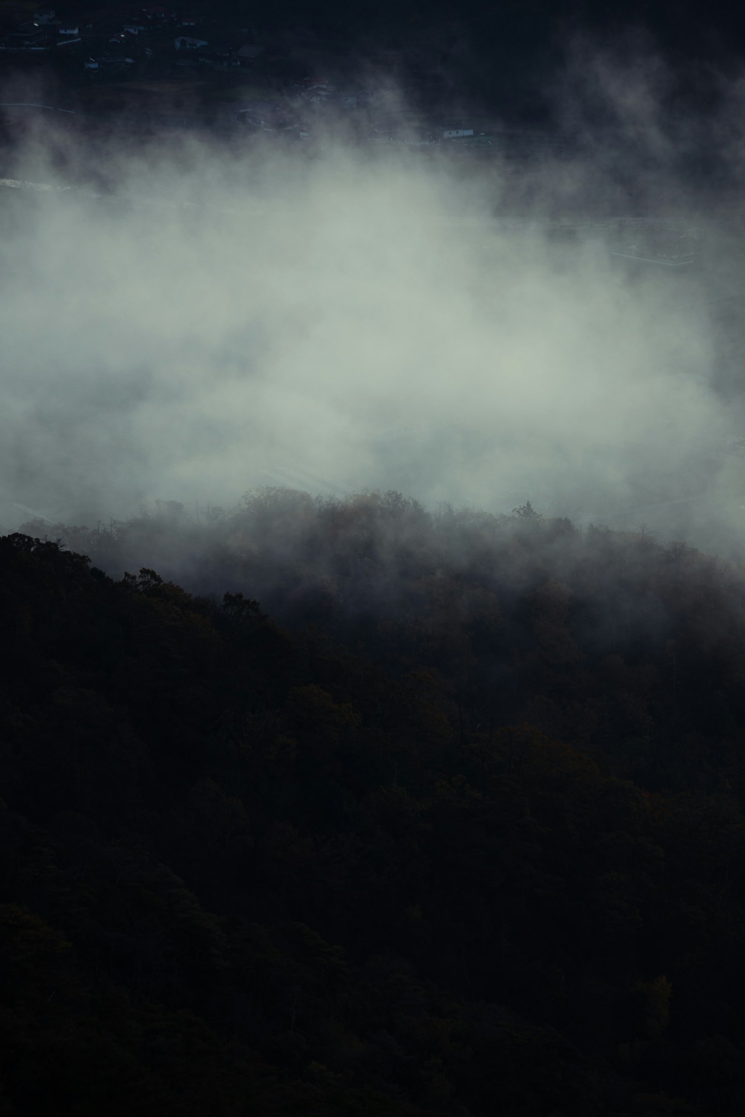 Misty mountain landscape with dark tones and a mysterious atmosphere