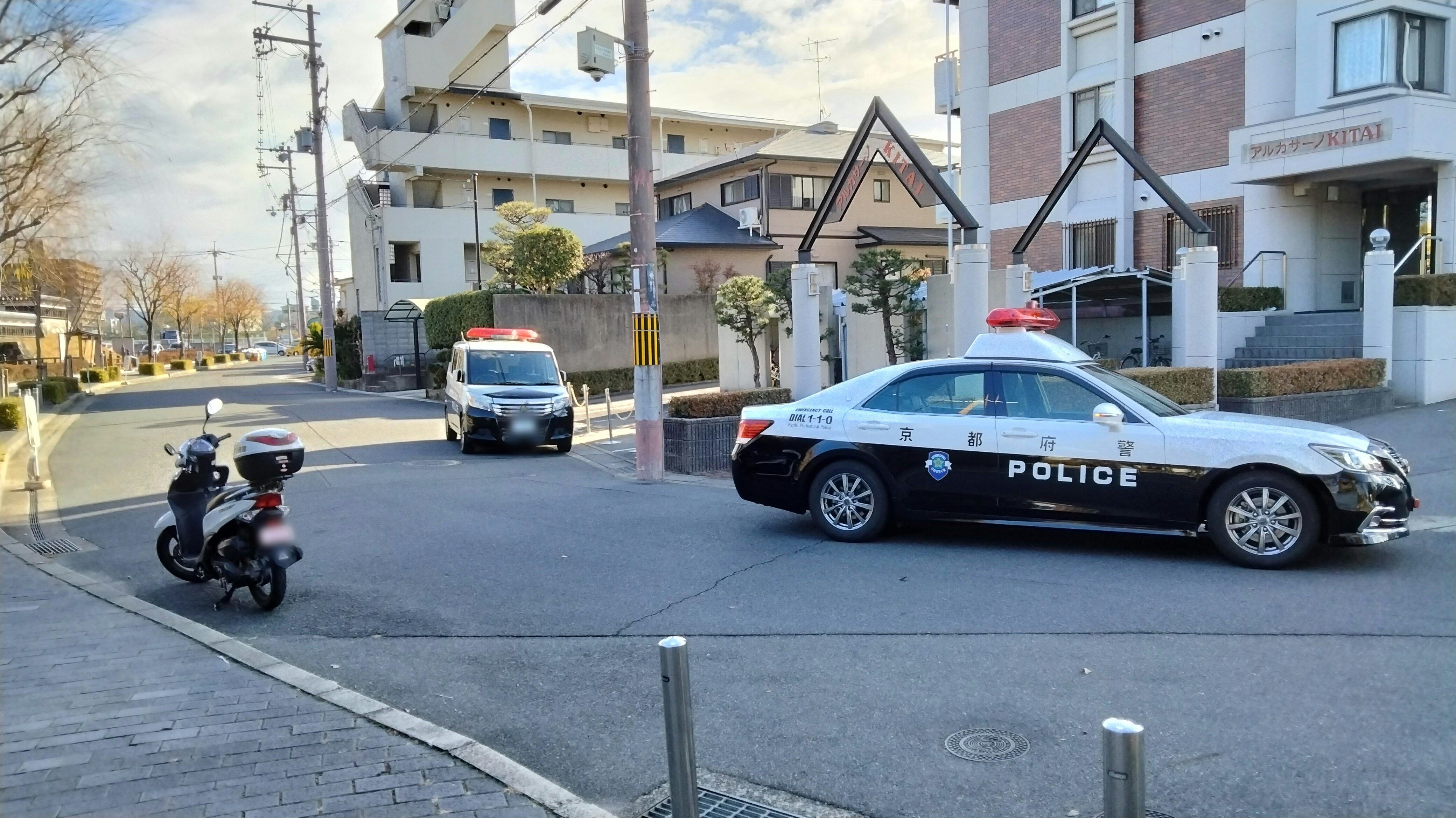coche de policía estacionado en una intersección con autos en una calle urbana