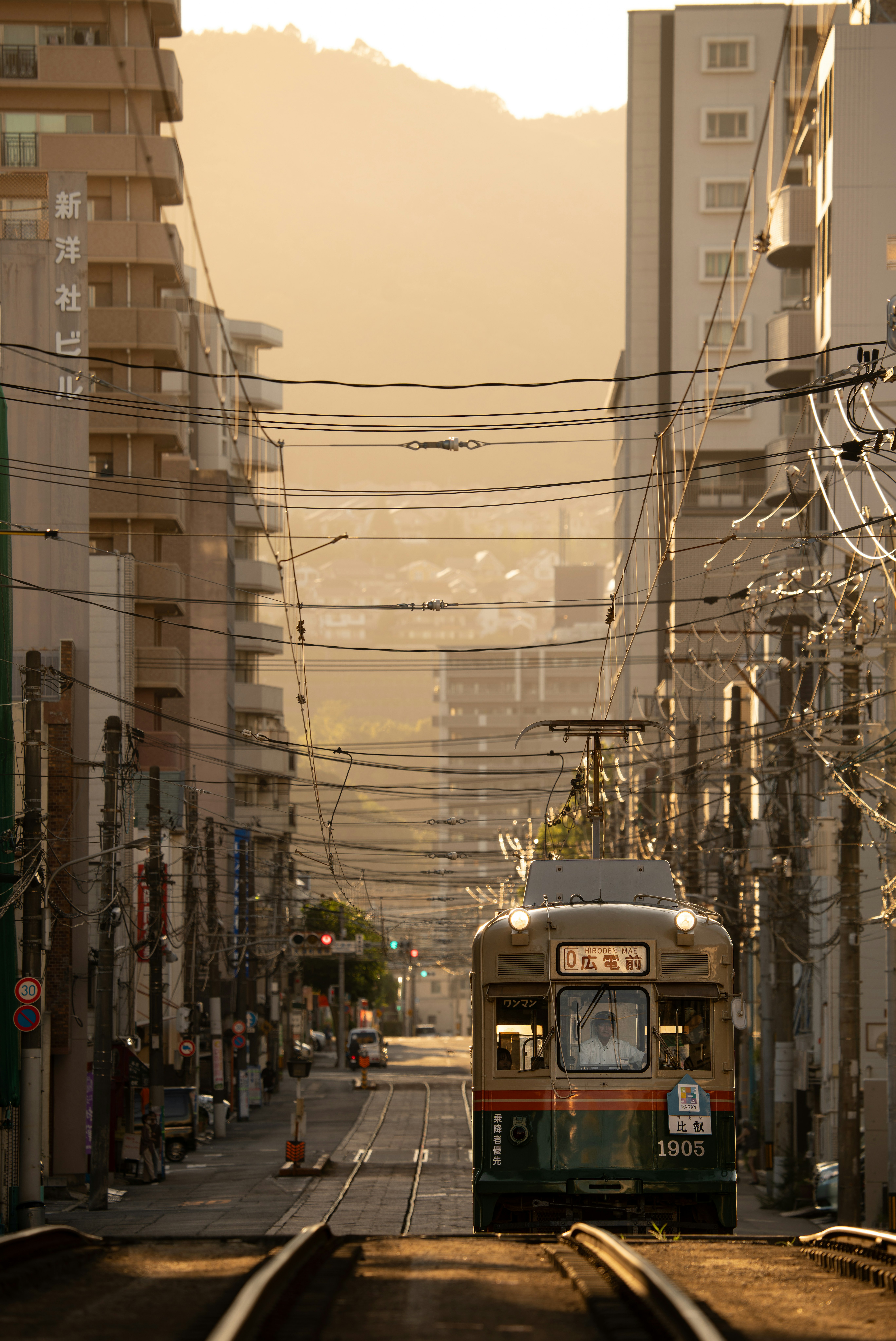 夕暮れの路面電車が走る広島の路地