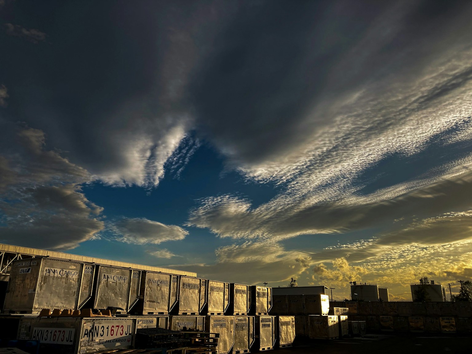 Vast sky with dramatic clouds and blue hues featuring golden light near the horizon