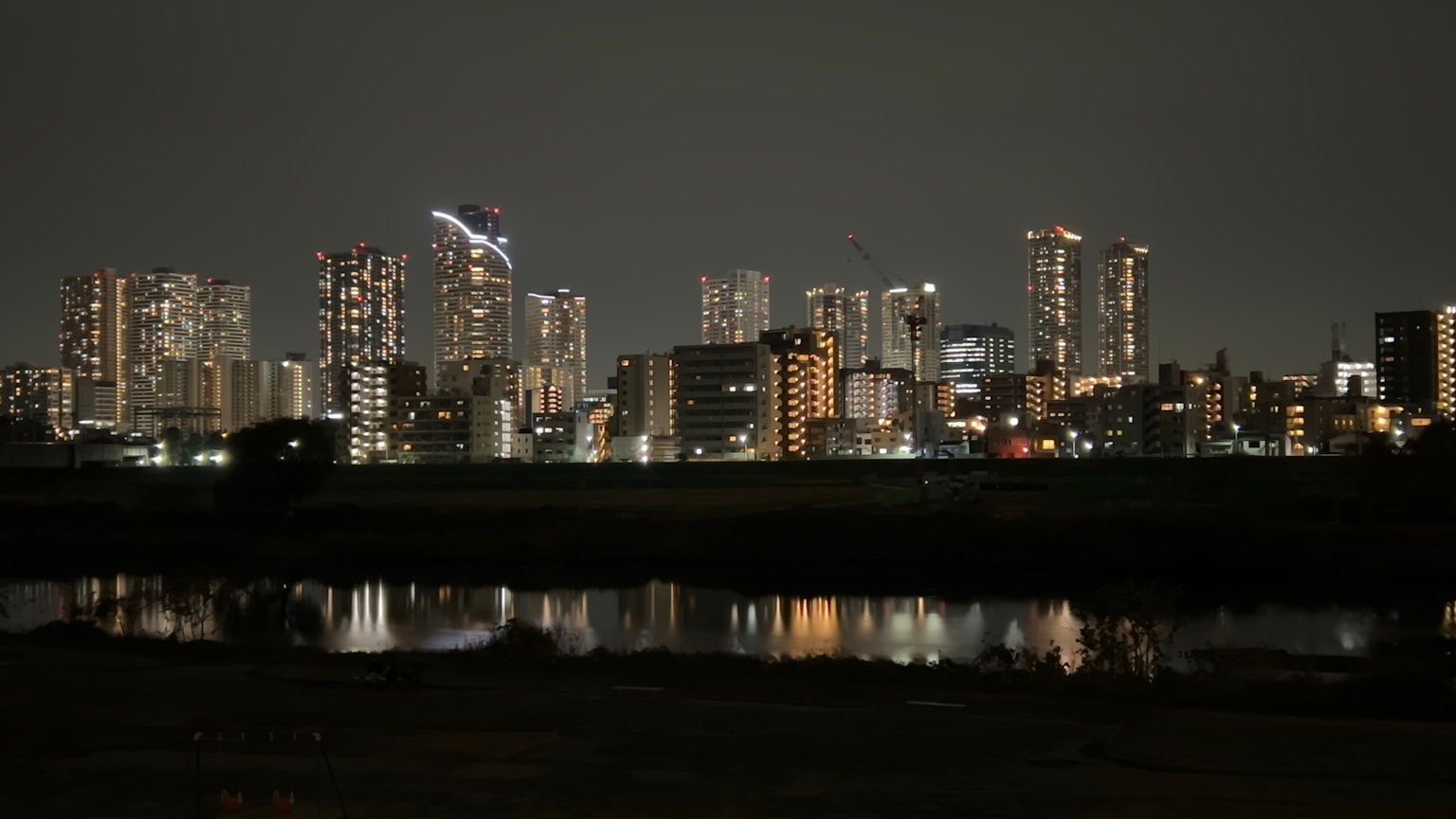 Pemandangan malam gedung pencakar langit Tokyo yang terpantul di sungai