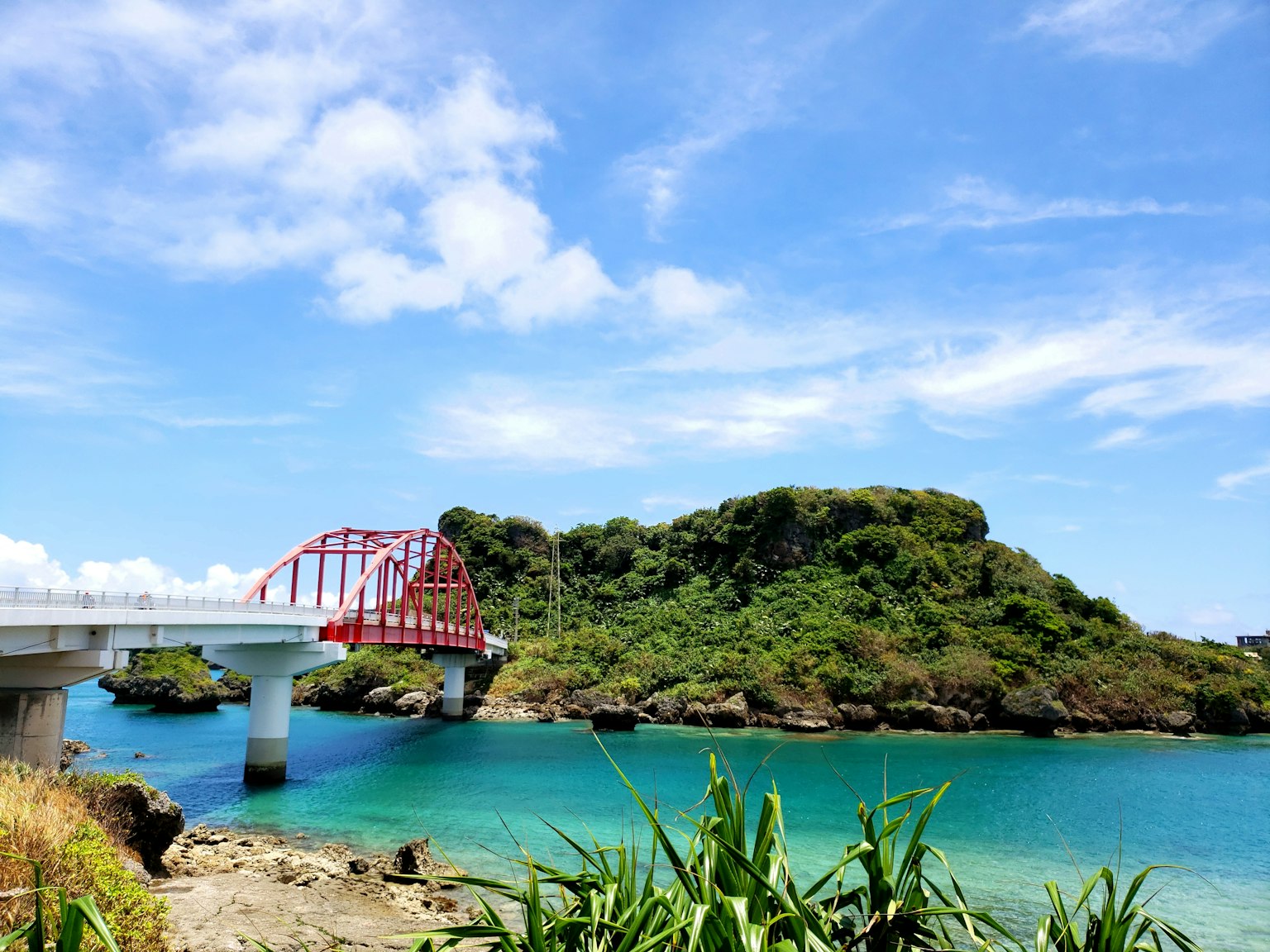 紅橋橫跨碧水與綠色島嶼的景觀