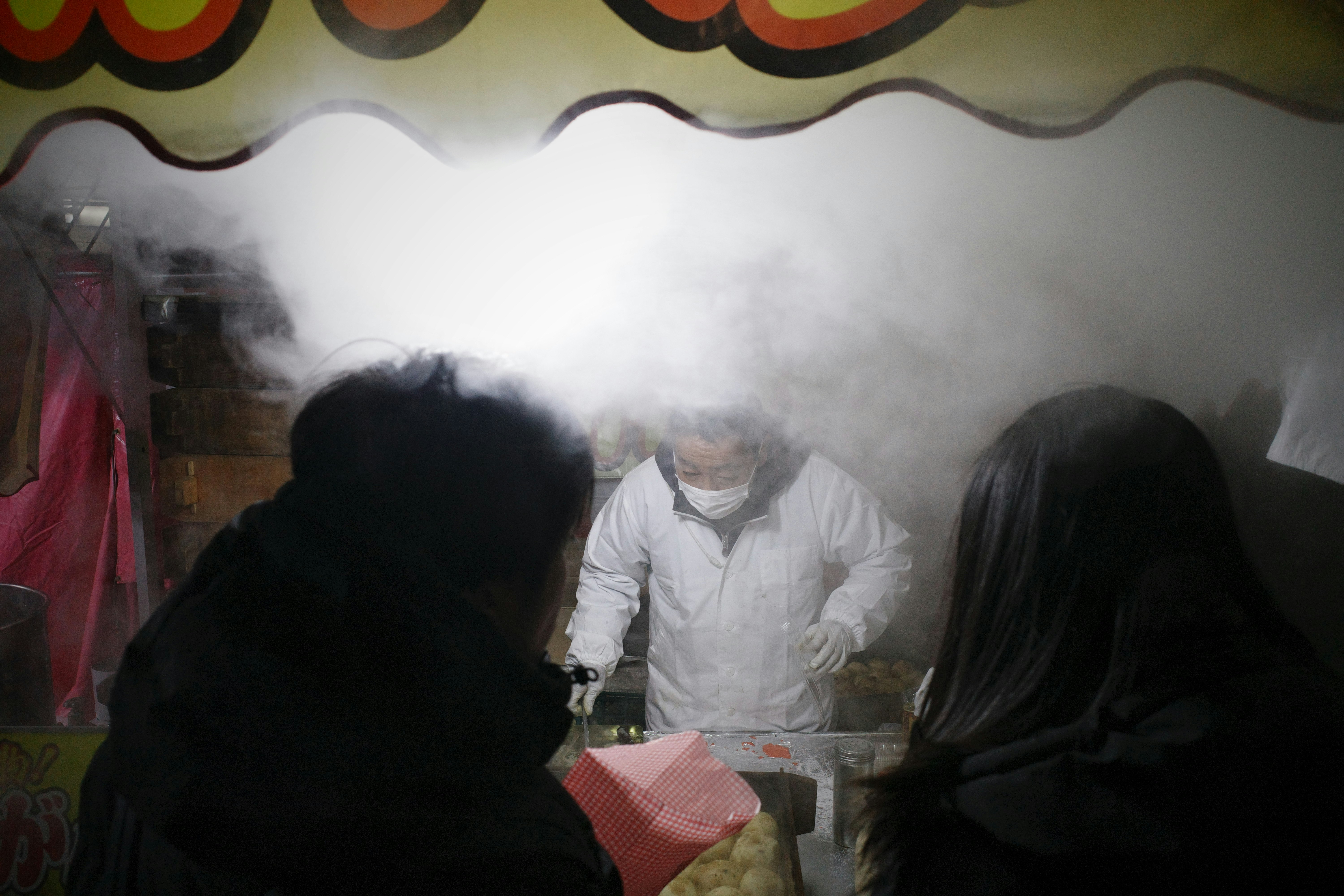 湯気の立つ屋台で正月の初詣を思わせる祭りの雰囲気