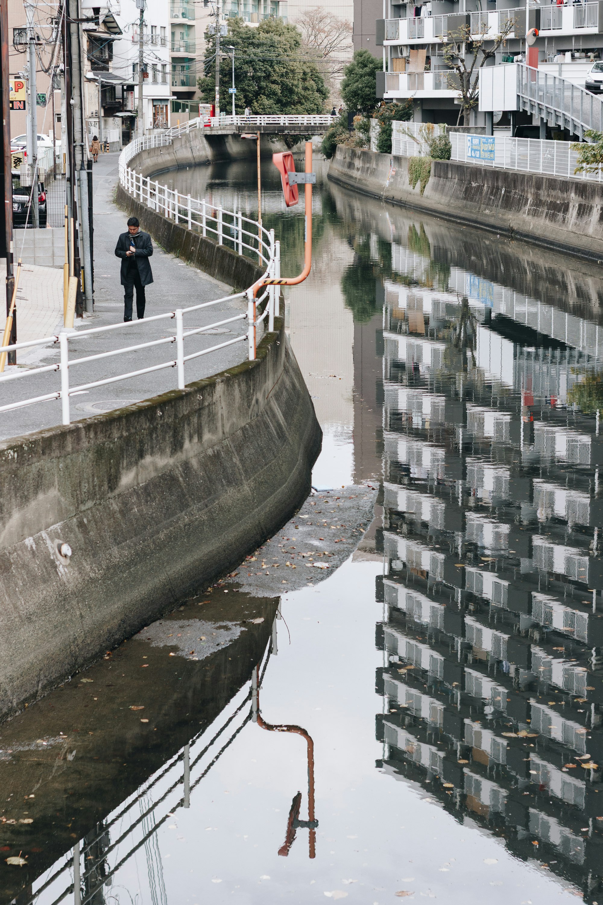 ruelle le long d’un canal avec murs de soutènement en pierre et immeubles d’habitation