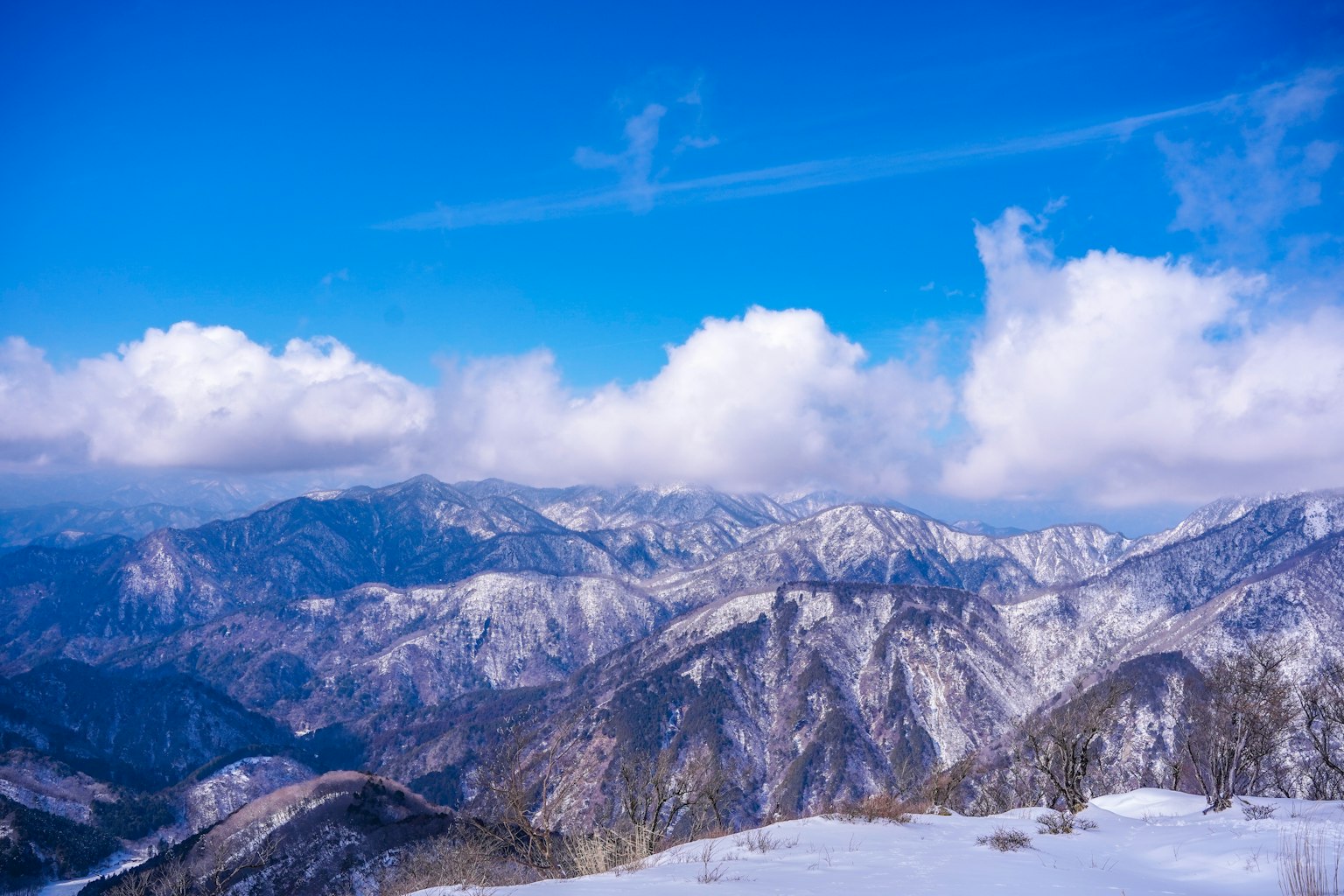 Gunung bersalju di bawah langit biru yang cerah