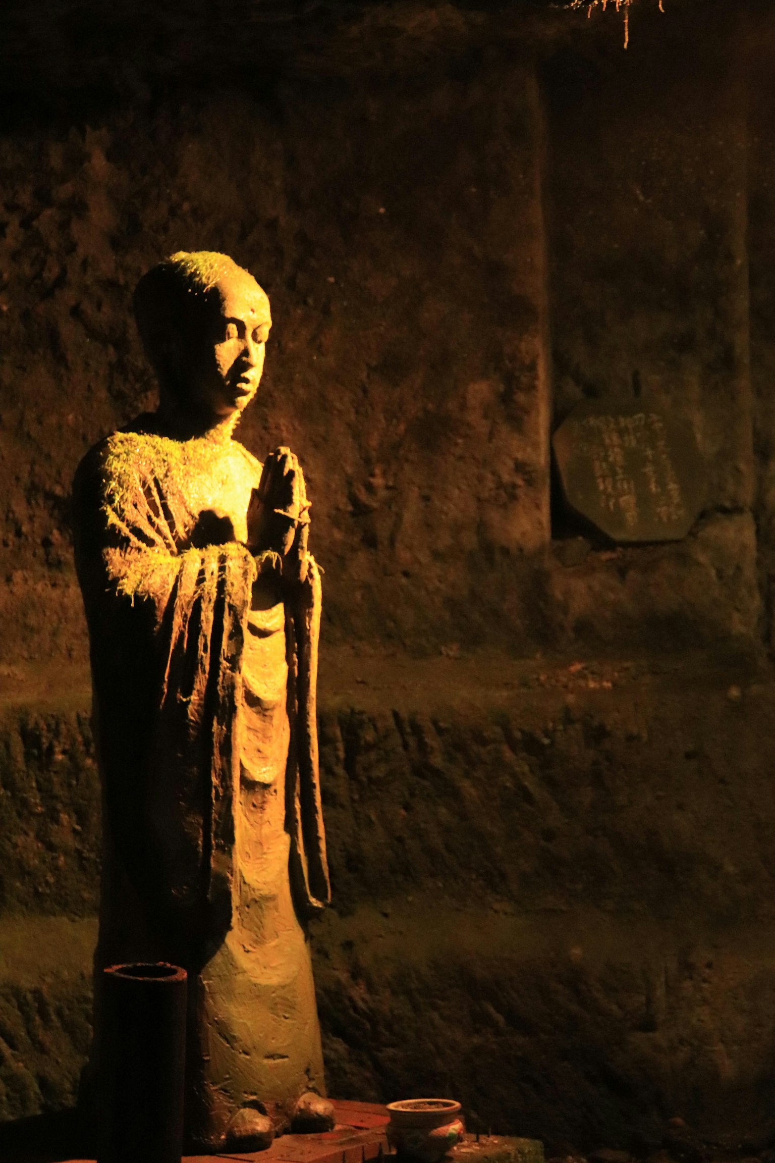 Eine Buddha-Statue in einem schwach beleuchteten Raum, beleuchtet von warmem Licht