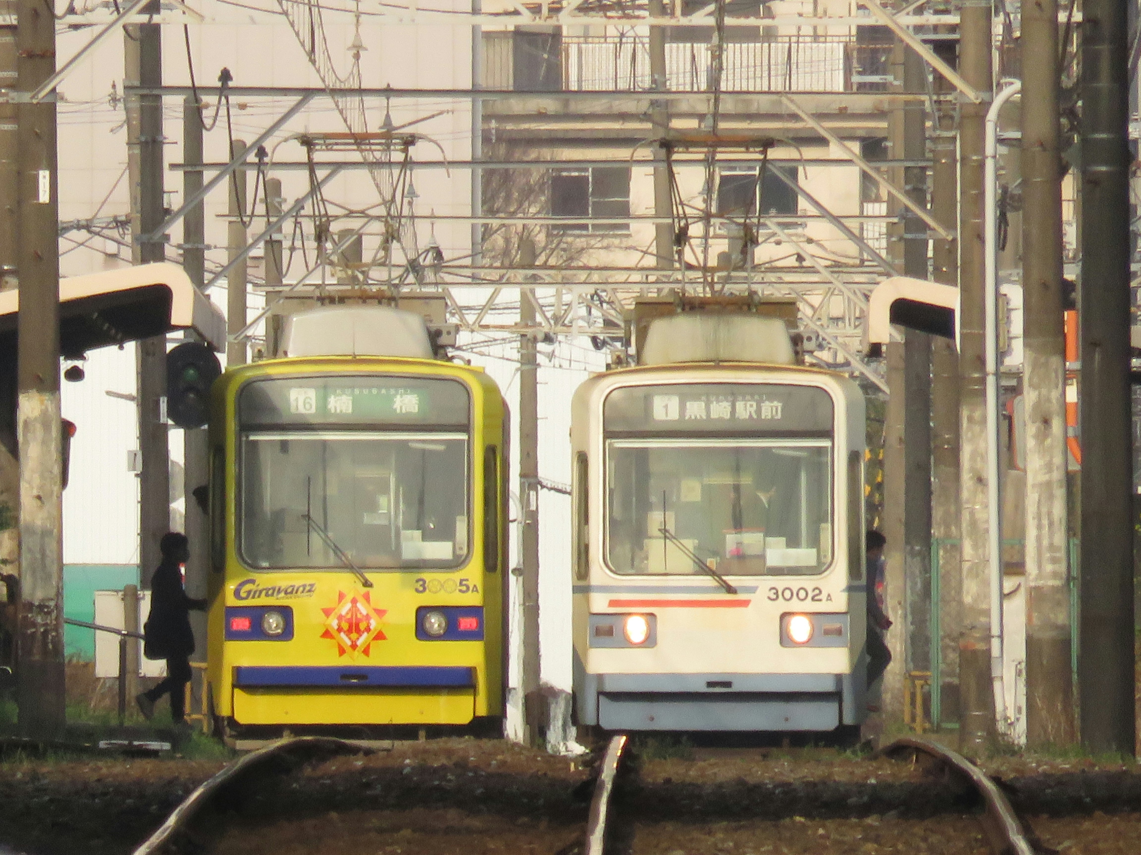 朝の通勤電車が並ぶ架線のある車庫の線路