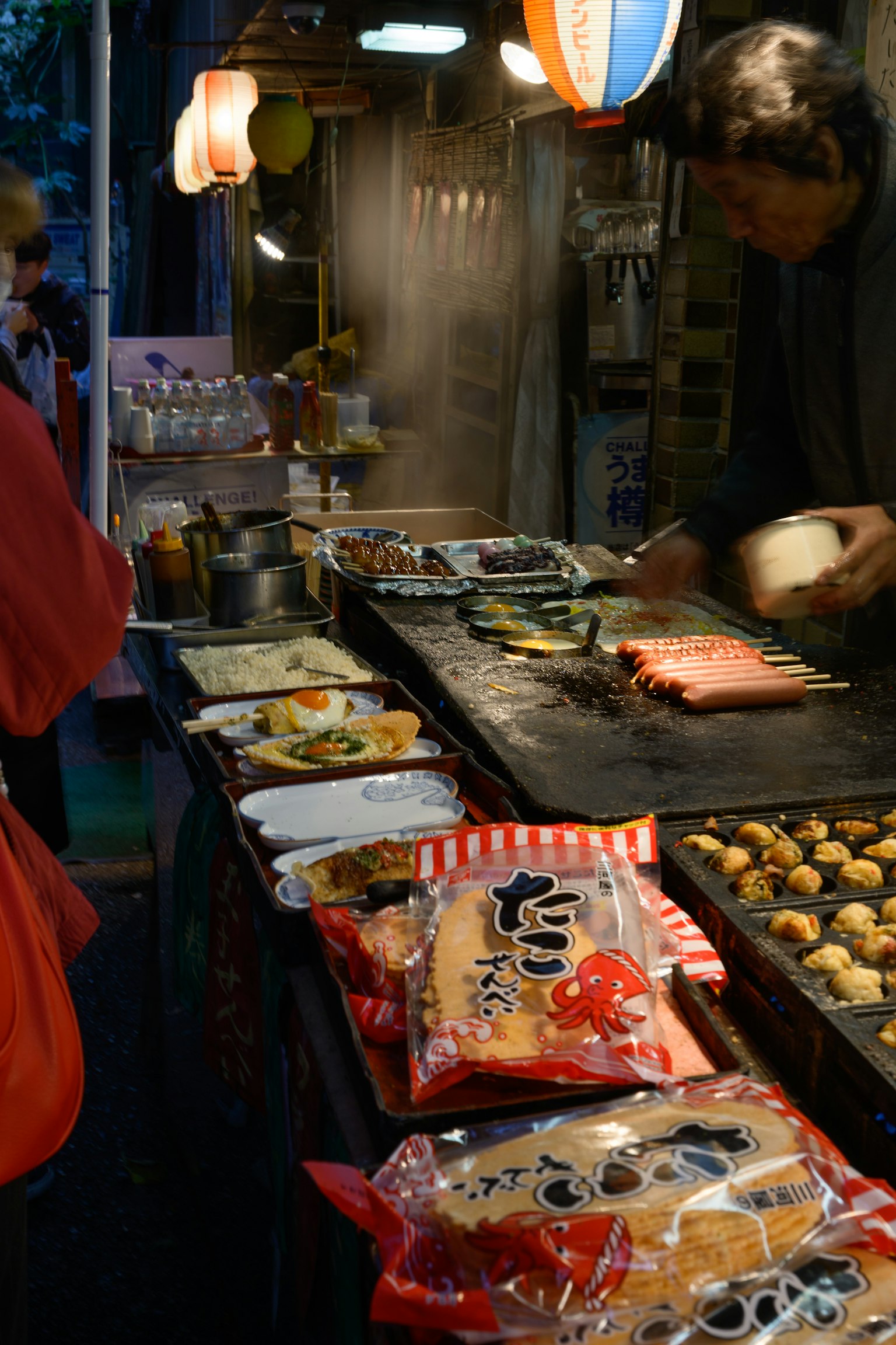 屋台で料理を作る男性と色とりどりの食べ物