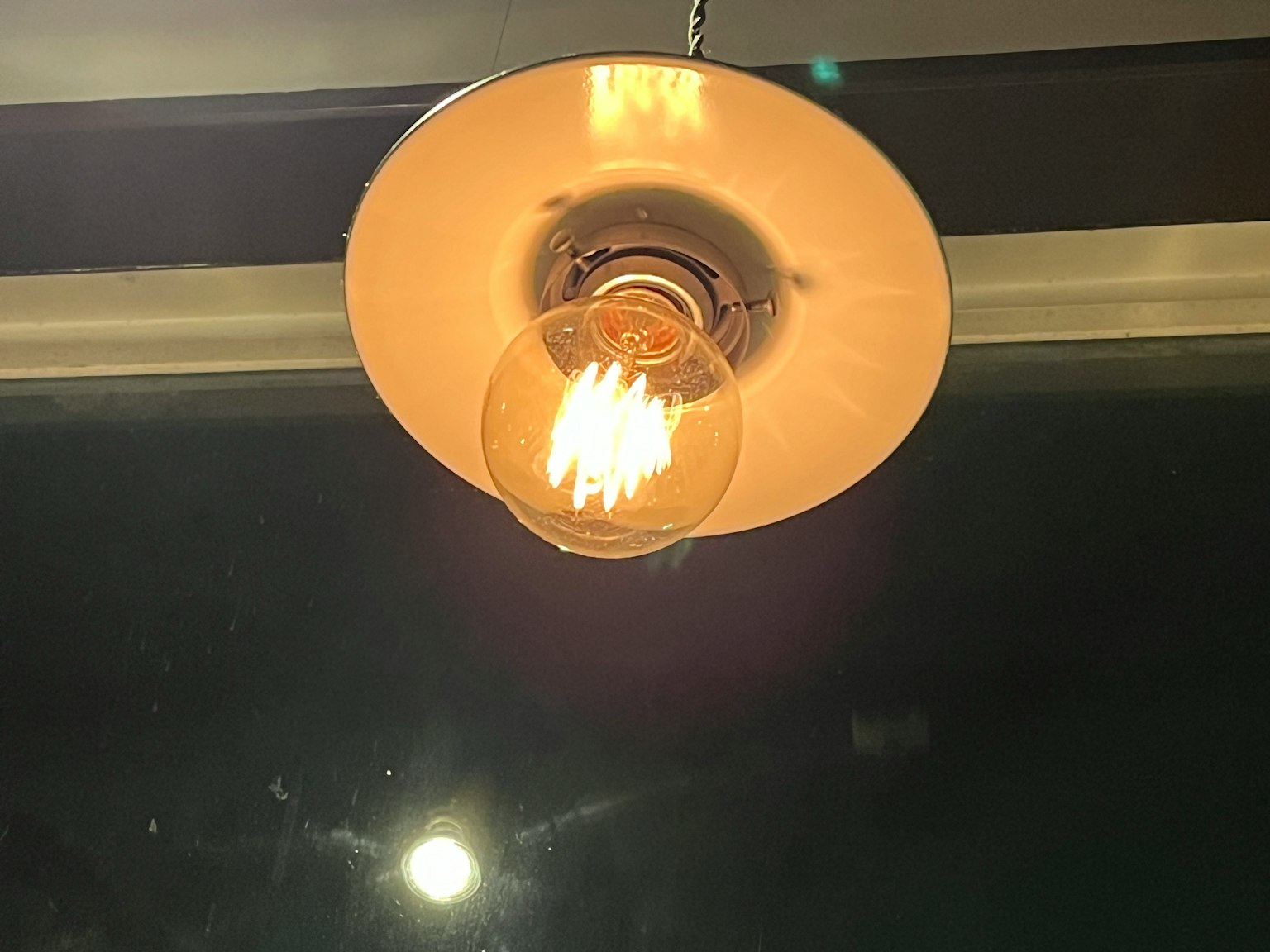 Semplice paralume appeso al soffitto con una lampadina luminosa