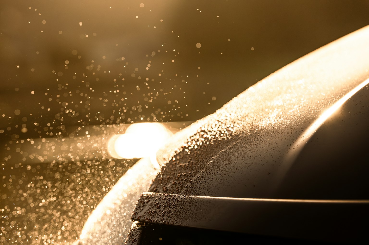 ภาพระยะใกล้ของฝากระโปรงรถที่มีน้ำกระเซ็น