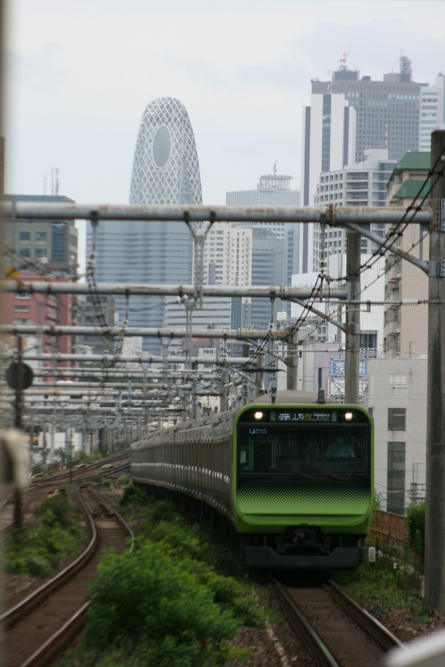 綠色列車穿過高樓大廈的城市風景