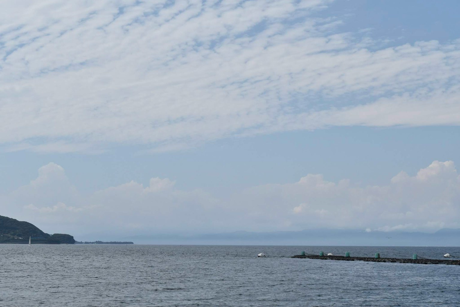 Ruhiges Meer mit blauem Himmel und verstreuten Wolken