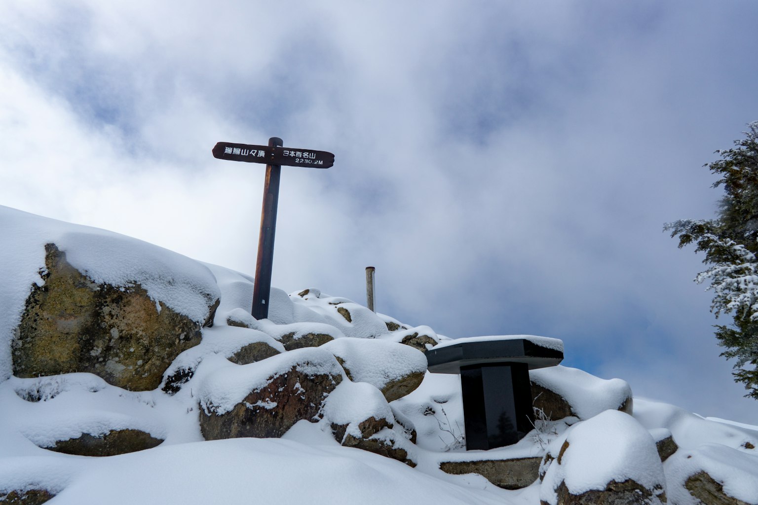 Pannello e panchina su rocce coperte di neve