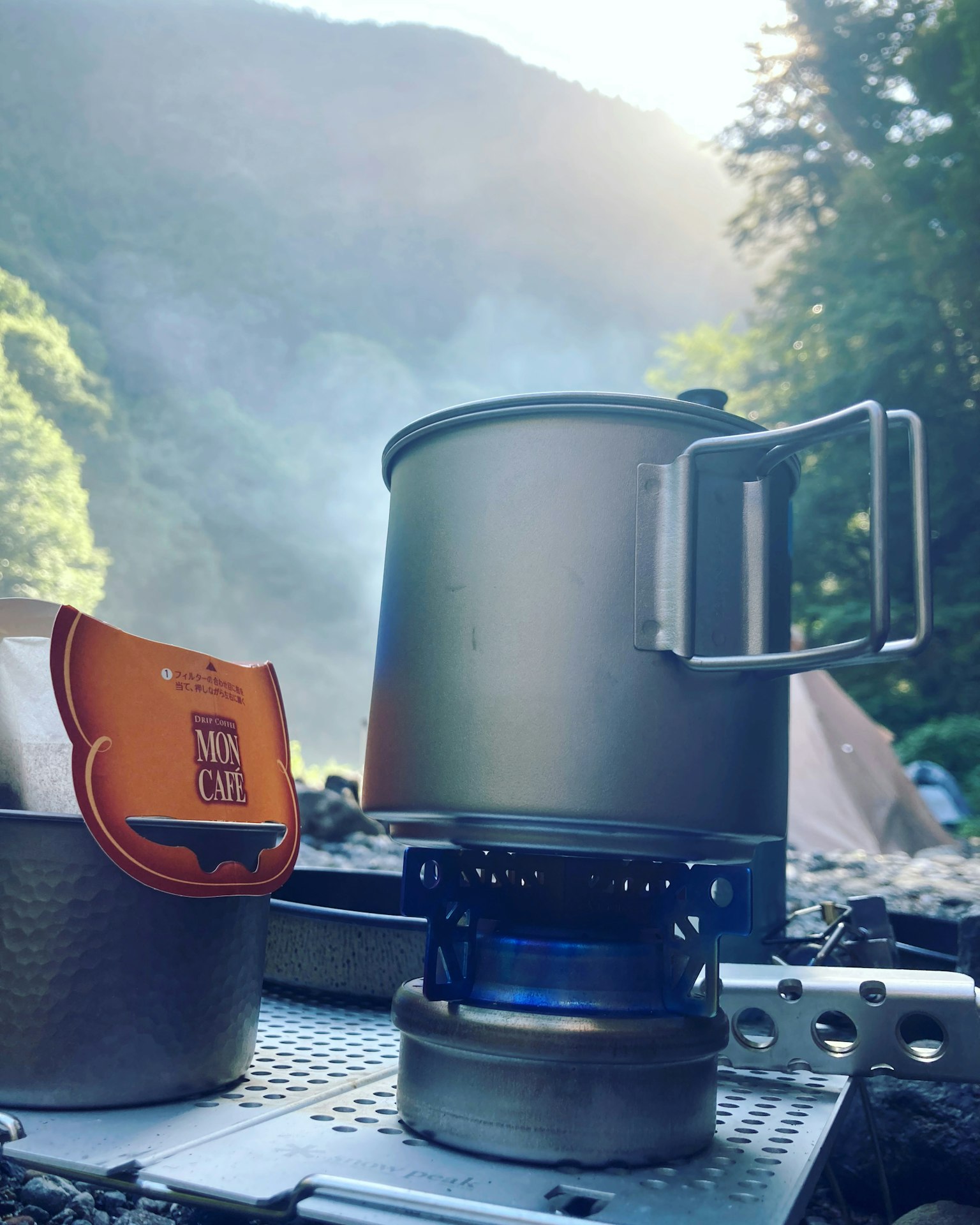 Kompor camping dan panci di lingkungan alami
