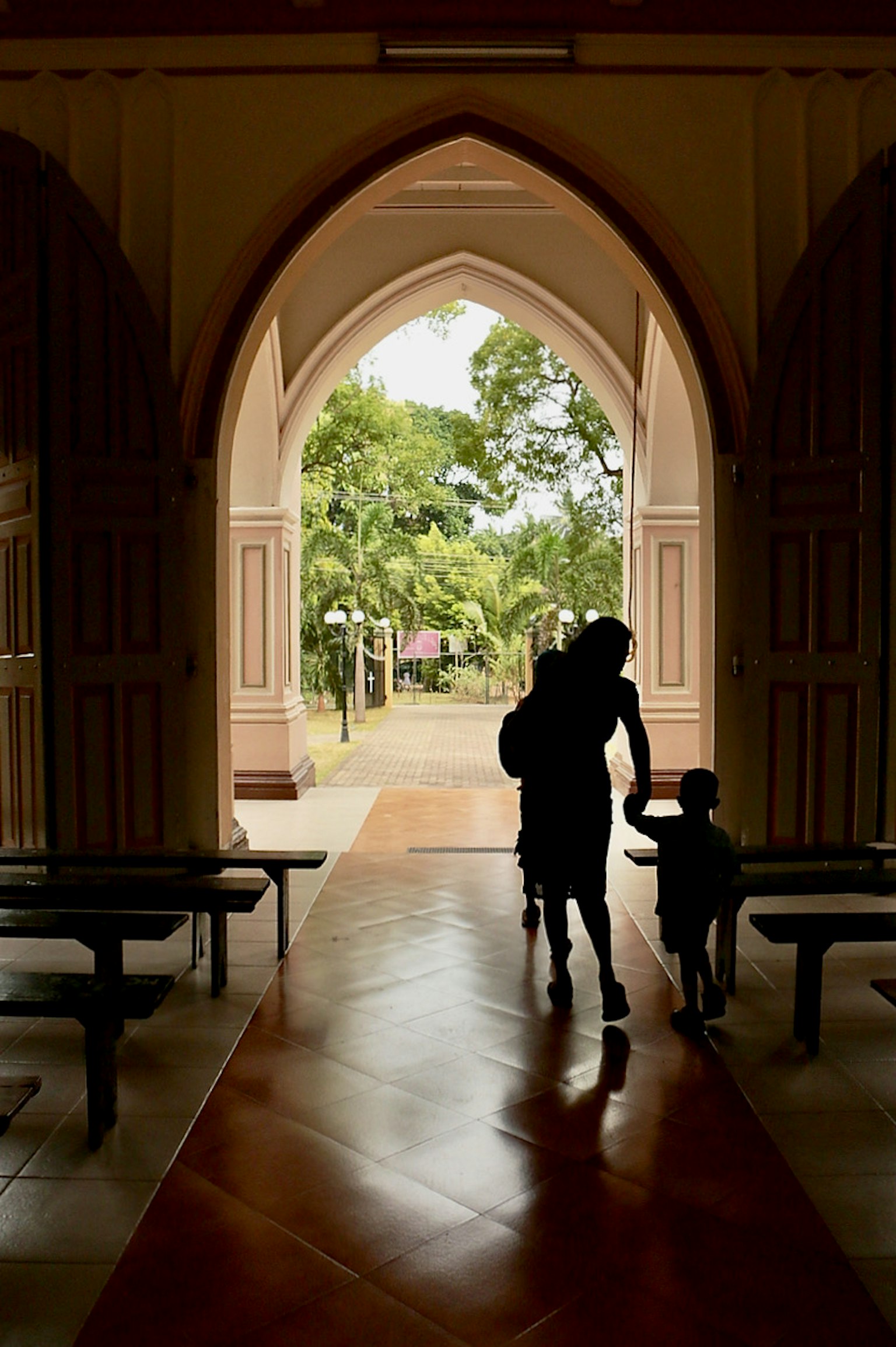 Silhouetted family exiting through an arched doorway