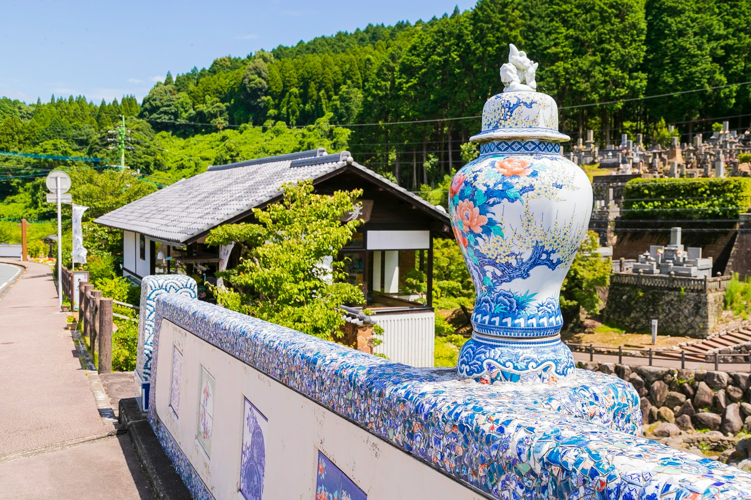 Große Vase mit blauen Blumenmustern in einer malerischen Landschaft