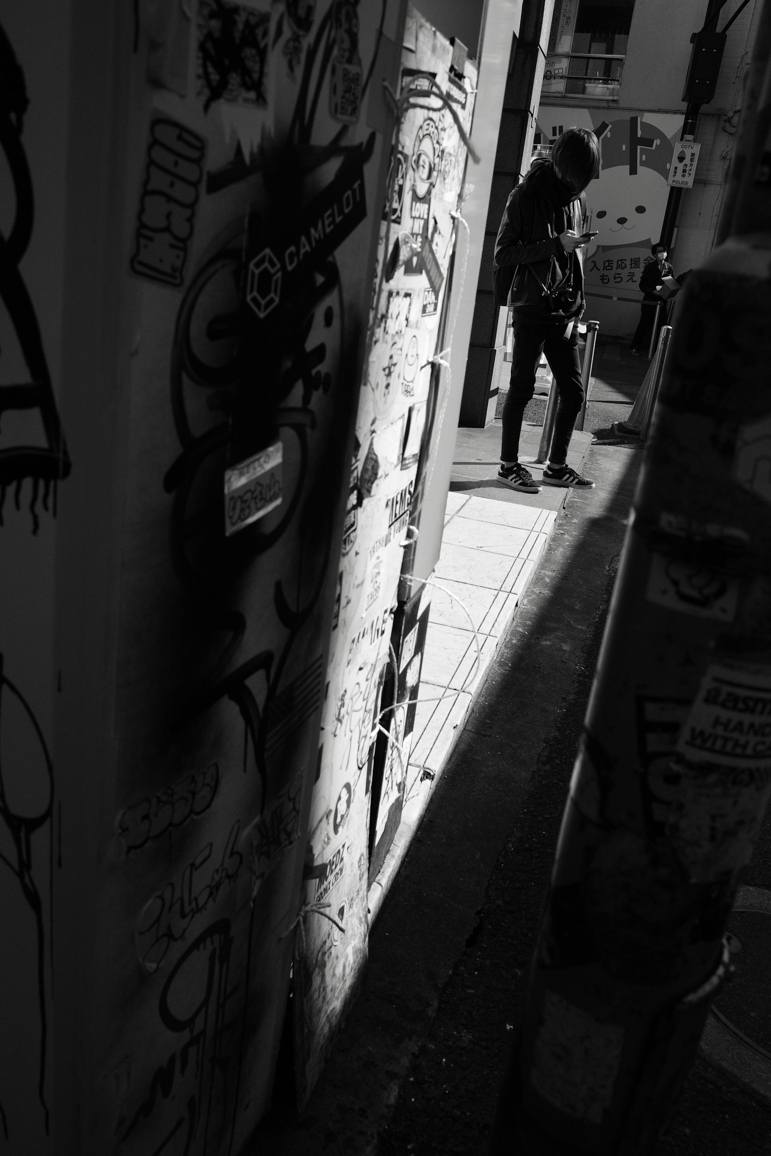 Người đứng trong một con hẻm tối với tranh graffiti trên tường