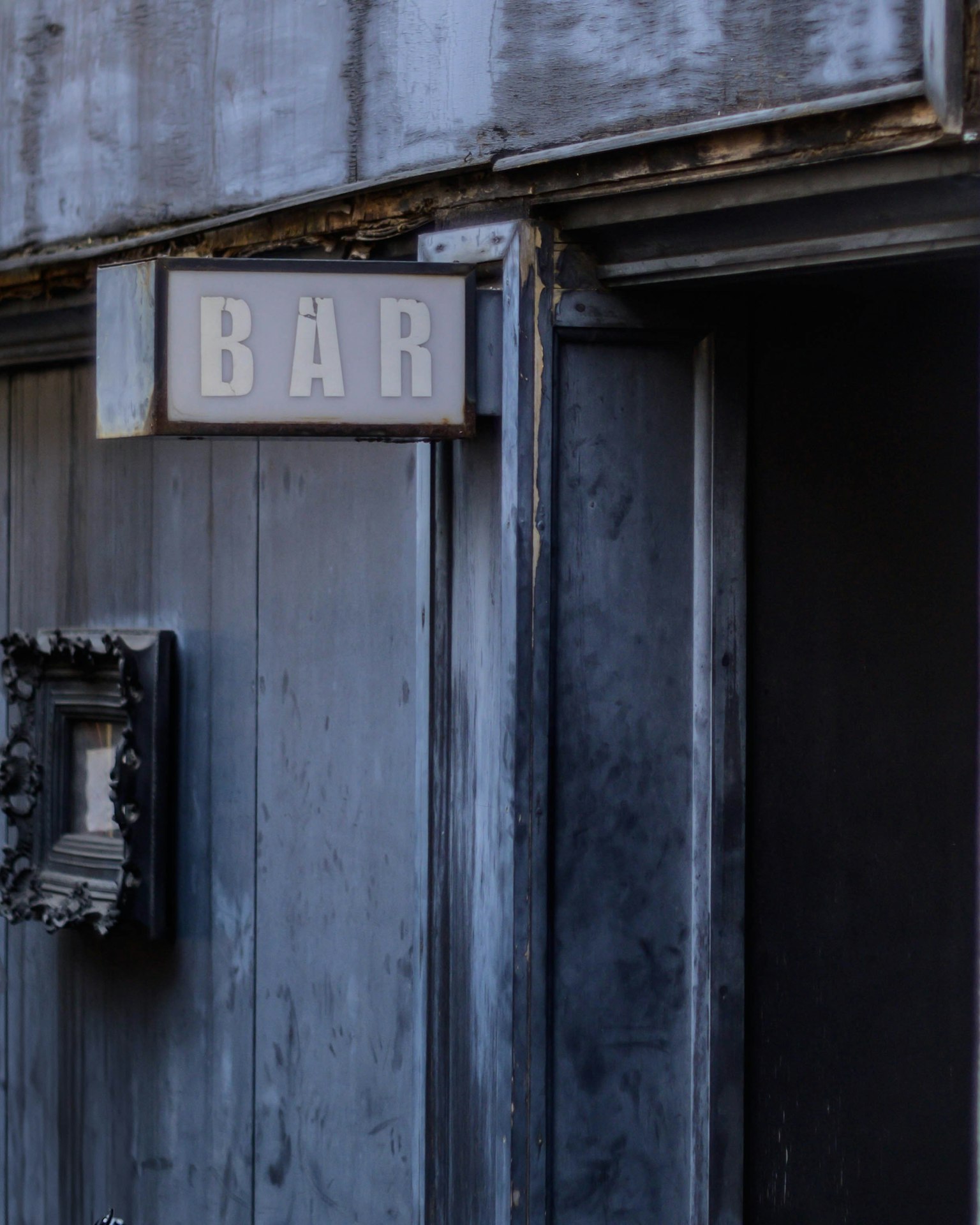 Cửa gỗ cũ với biển hiệu quán bar