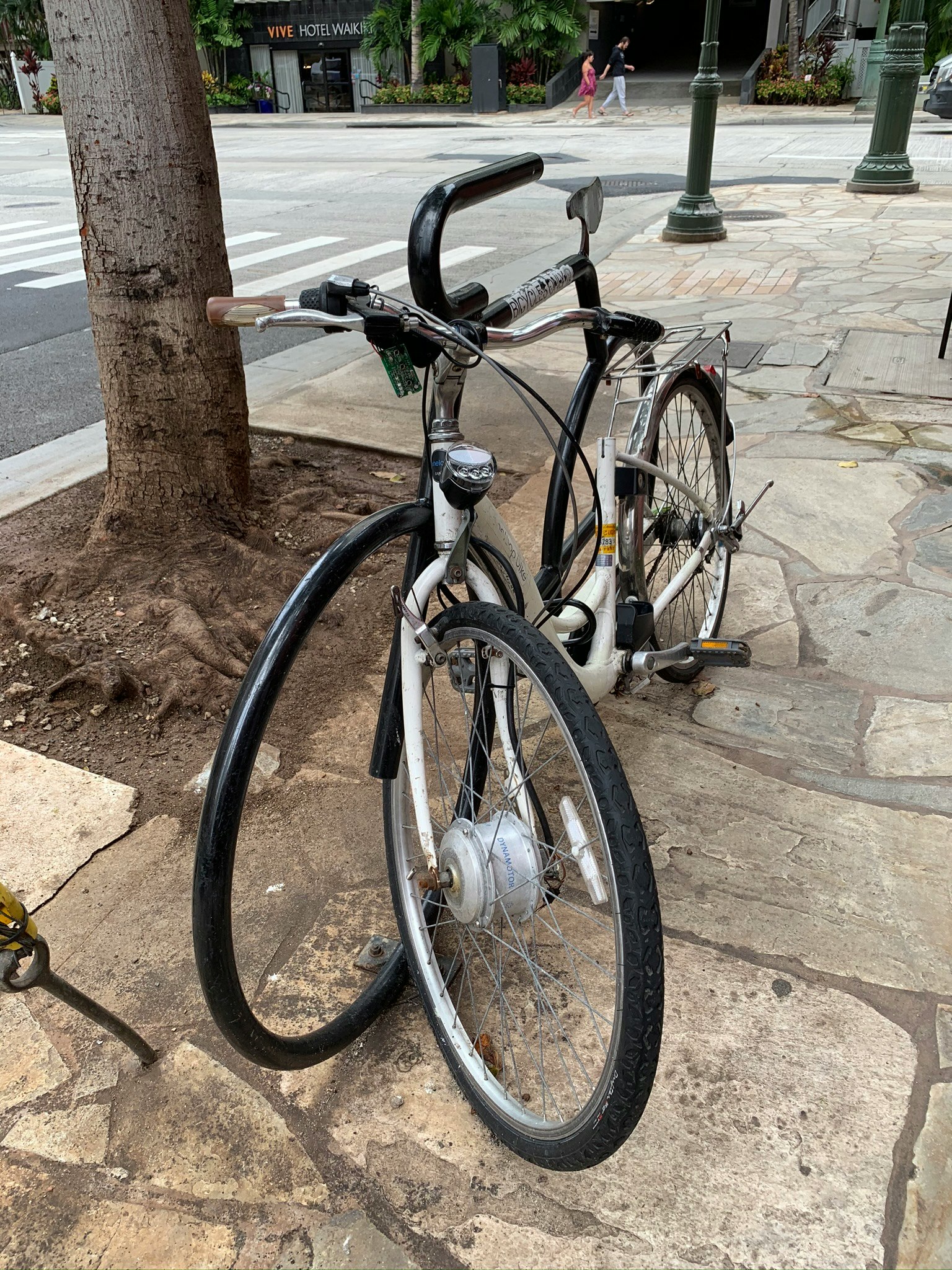 Vélo garé sur une rue pavée à côté d'un arbre