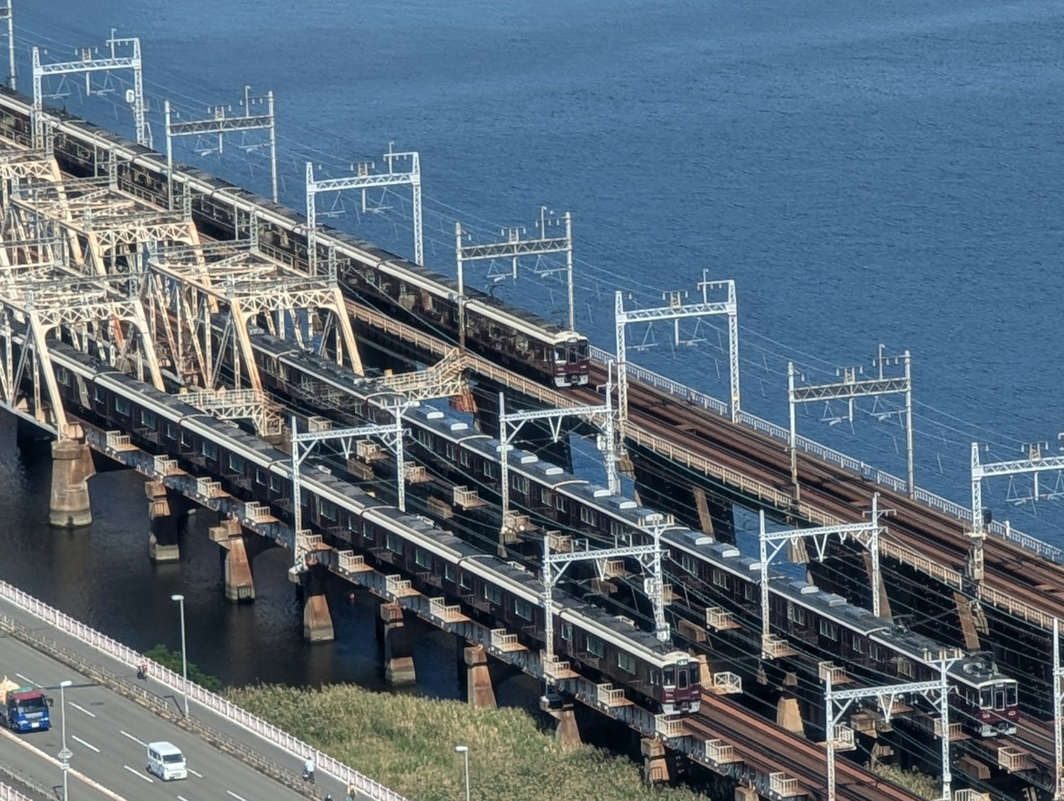 มุมมองจากอากาศของสะพานรถไฟที่มีรถไฟวิ่งข้ามน้ำ