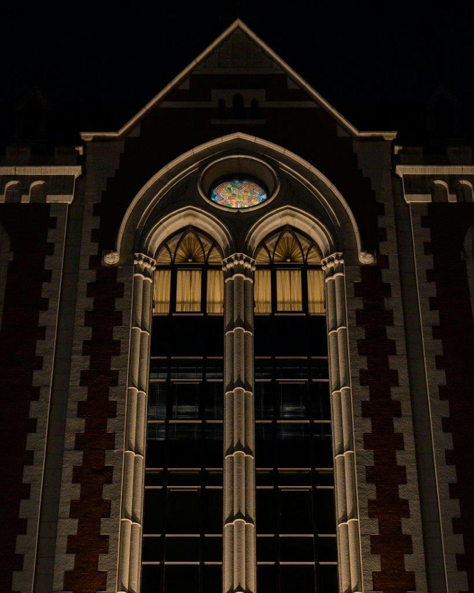 Détail architectural d'un bâtiment avec des fenêtres en arc illuminées la nuit