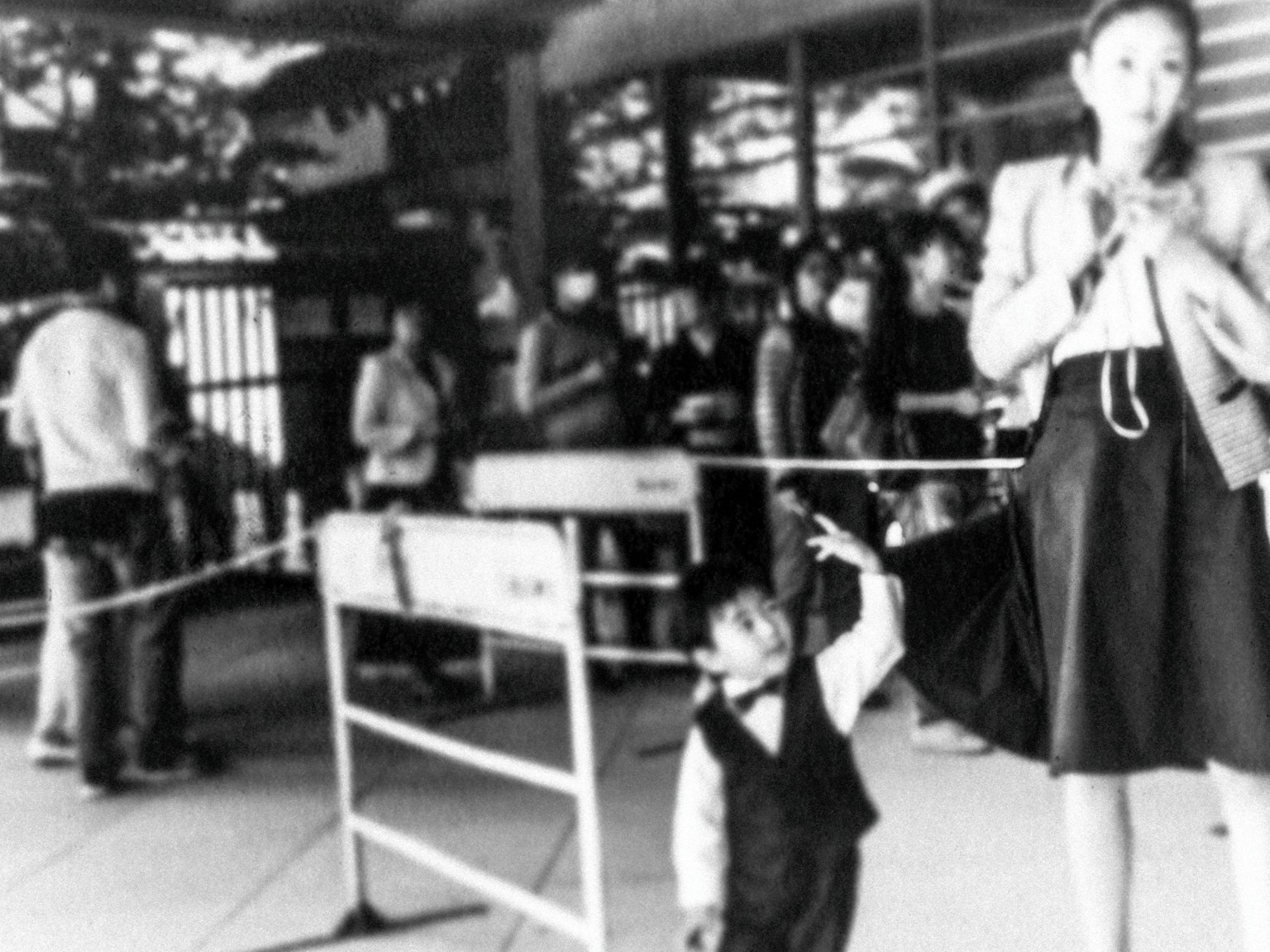 Foto in bianco e nero di una donna adulta e un bambino in un'area affollata