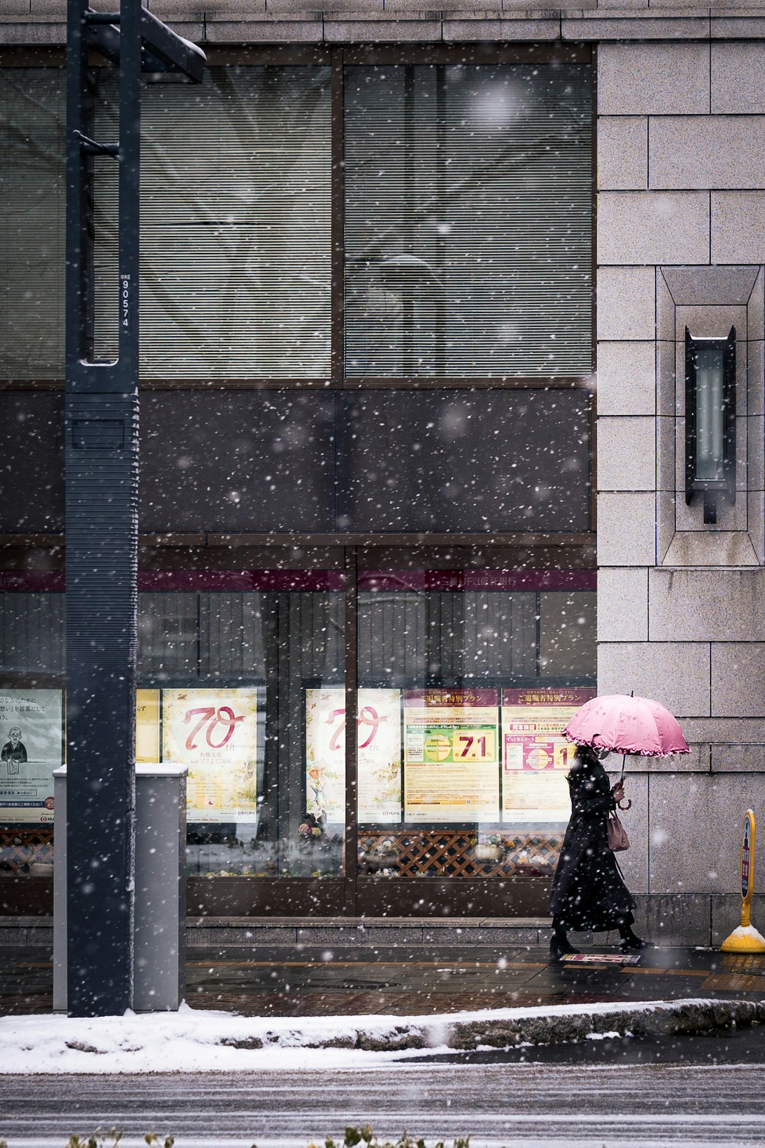 Person walking with a pink umbrella in the snow
