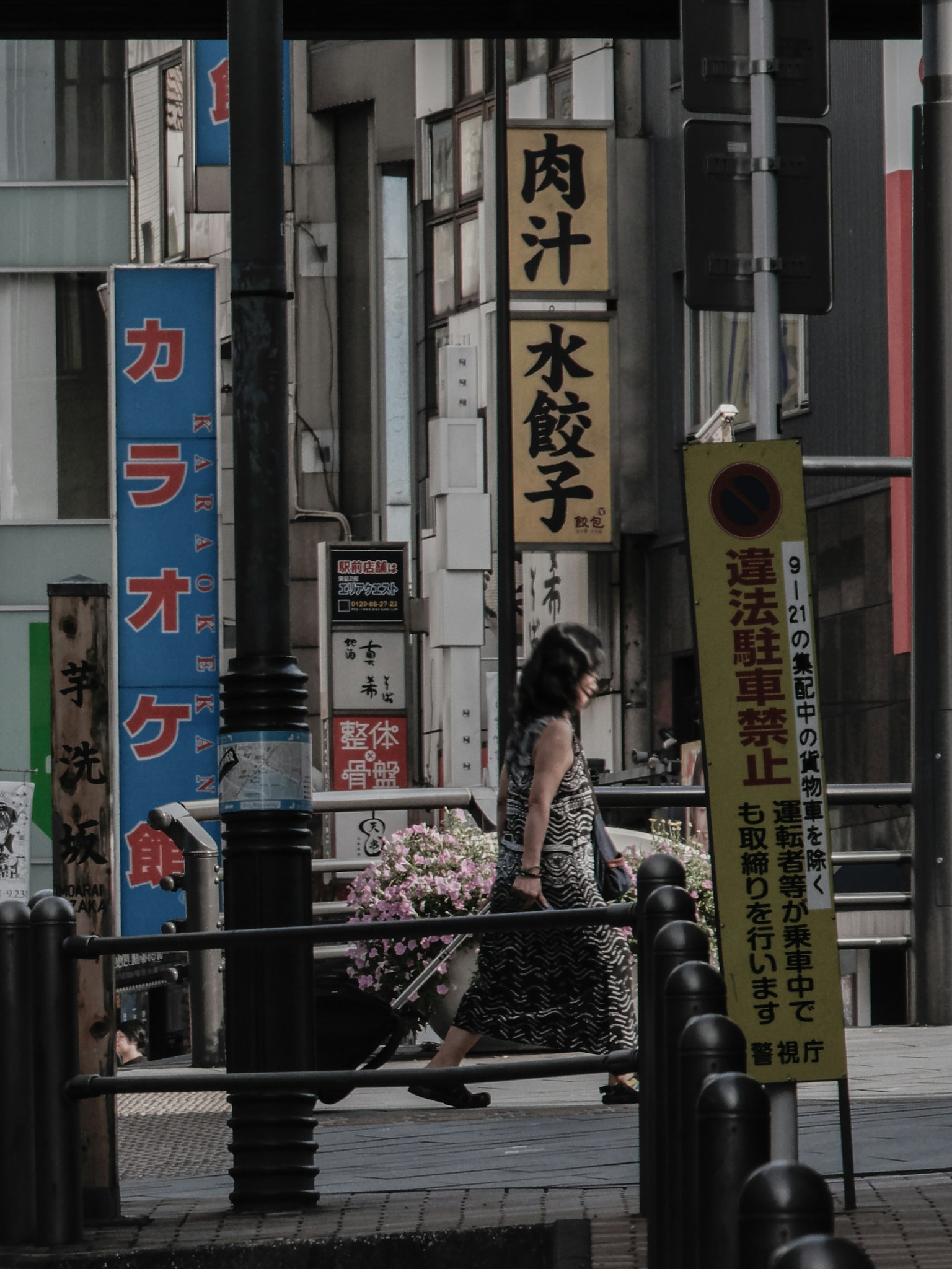 A street scene with a person walking surrounded by various signs