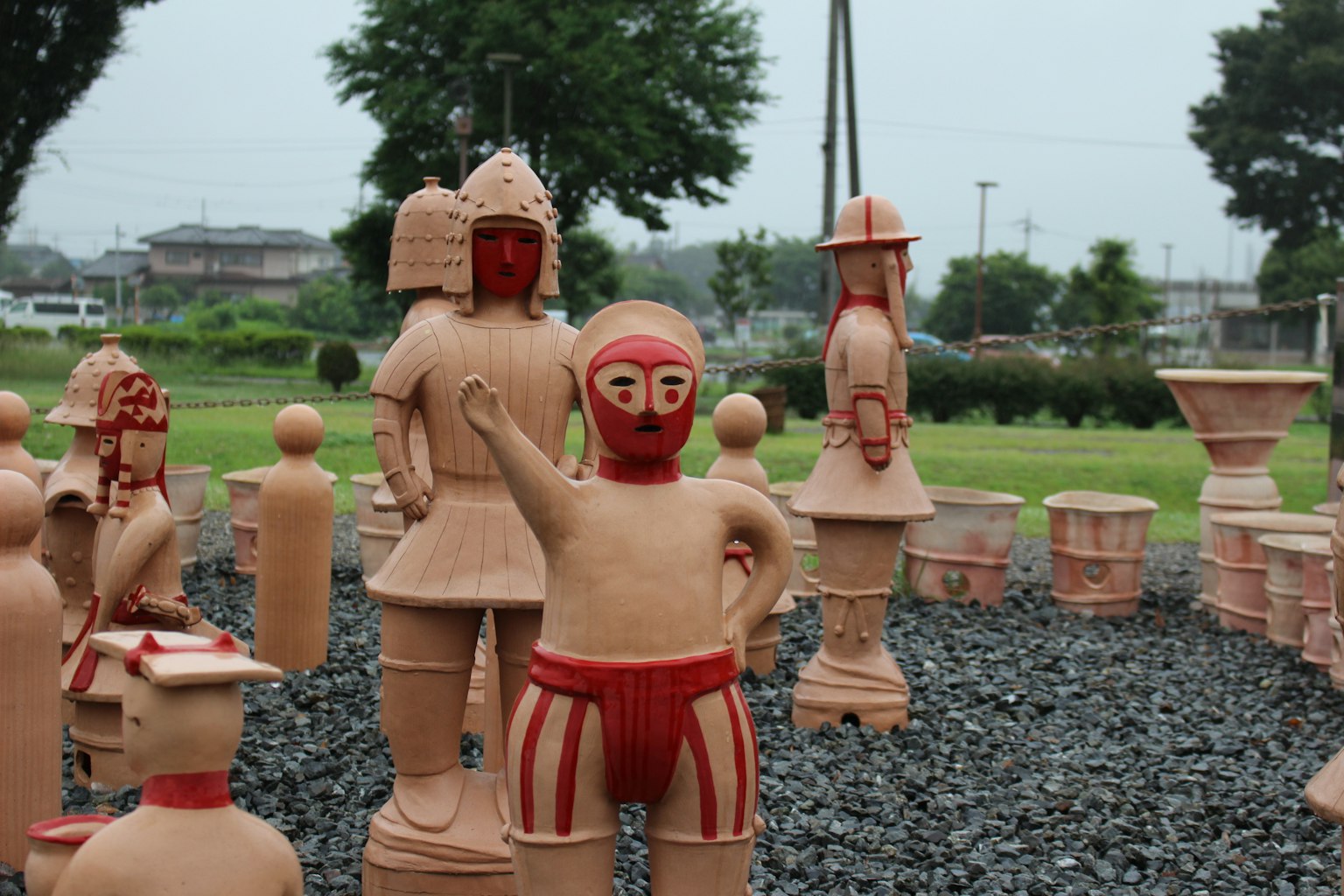 A park scene featuring terracotta figures with bright colors and a green background