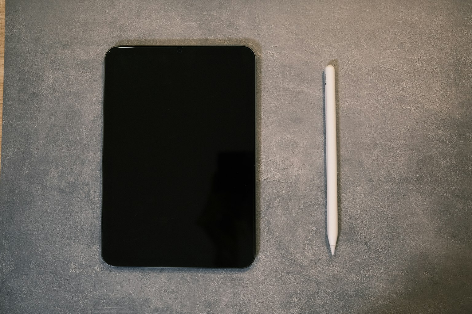 Schwarzes Tablet und weißer Stylus nebeneinander