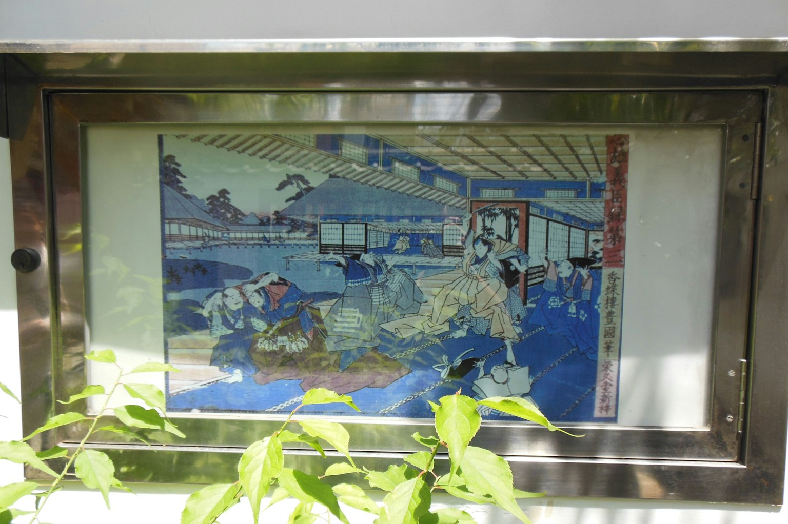 Immagine di una stampa ukiyo-e giapponese tradizionale esposta in una cornice di vetro con vegetazione