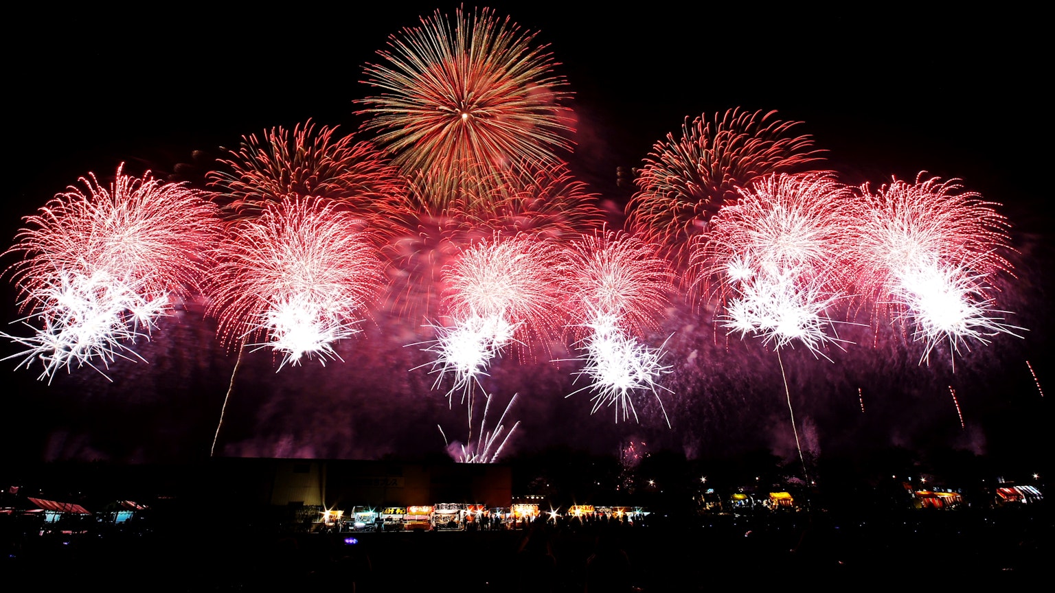 Espectáculo de fuegos artificiales rojos y blancos en el cielo nocturno
