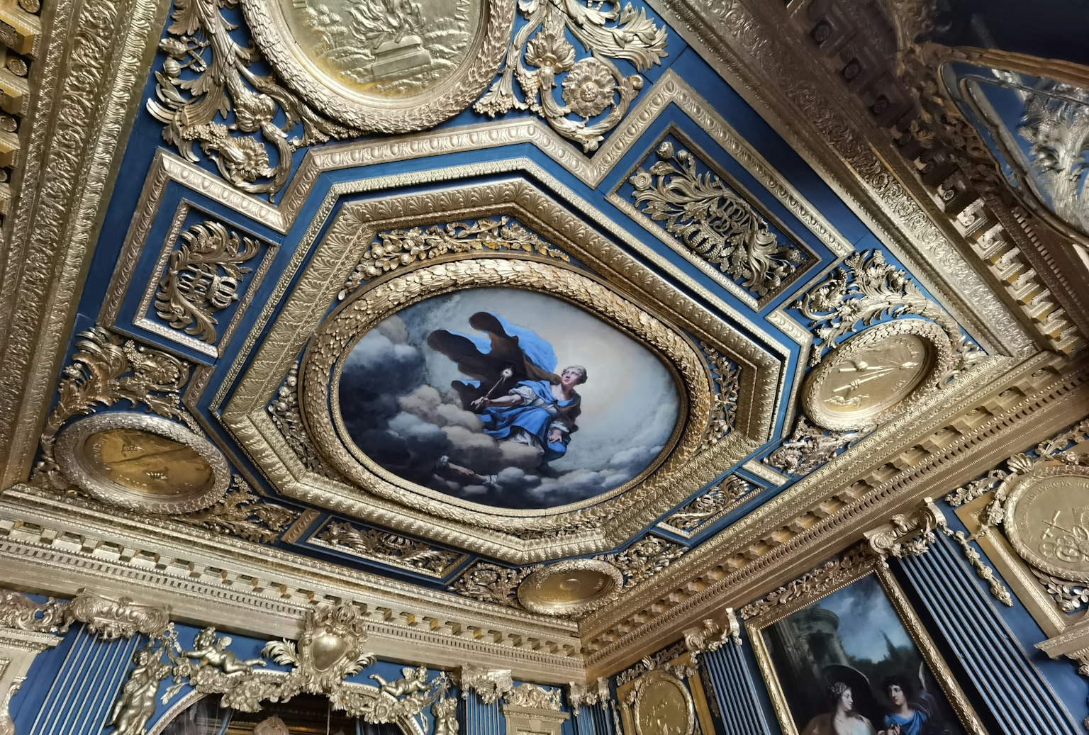 Decorazione del soffitto lussuosa con un dipinto su sfondo blu