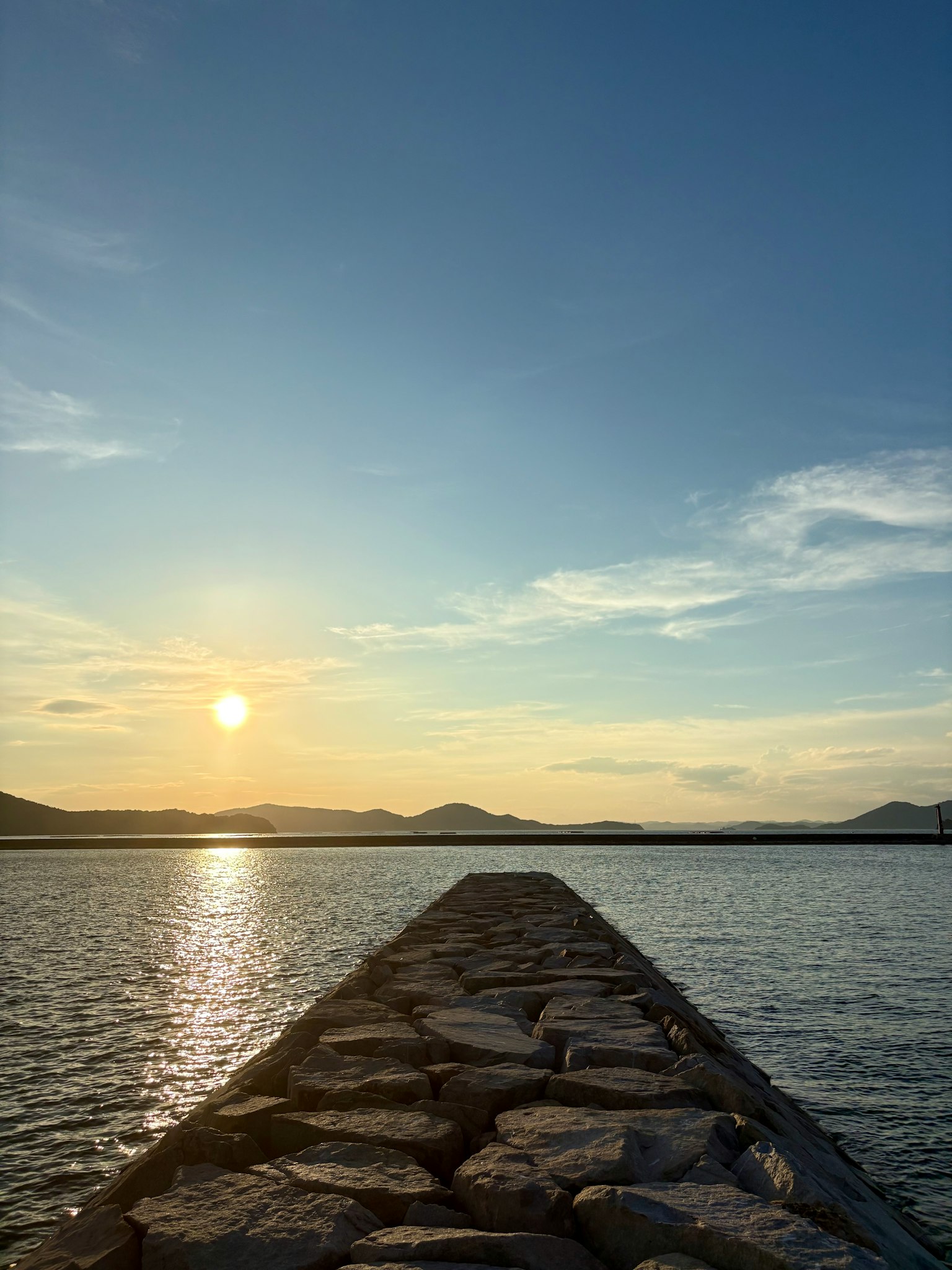 石でできた桟橋が水面に向かって伸びている夕暮れの風景