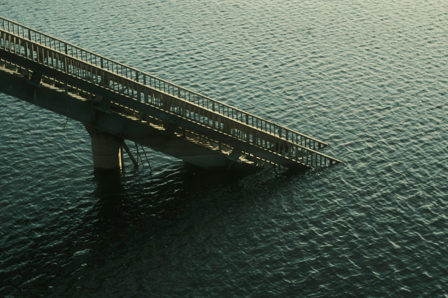 水面に突き出た橋の一部と穏やかな波