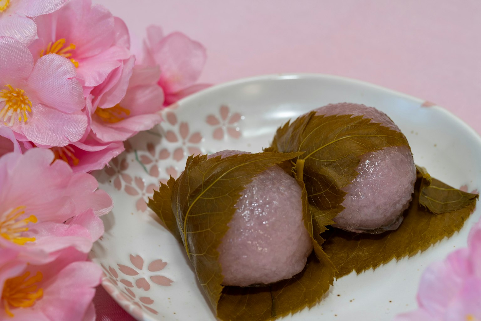 Plato de sakura mochi junto a flores de cerezo
