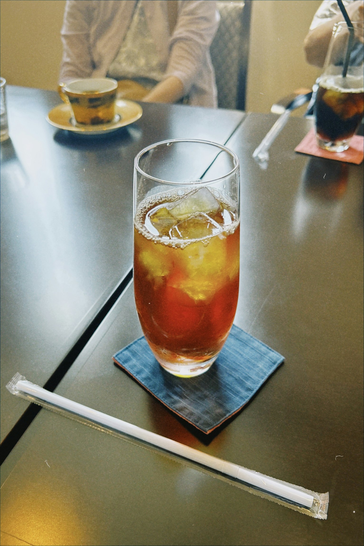 Vaso de té helado en una mesa con un posavasos