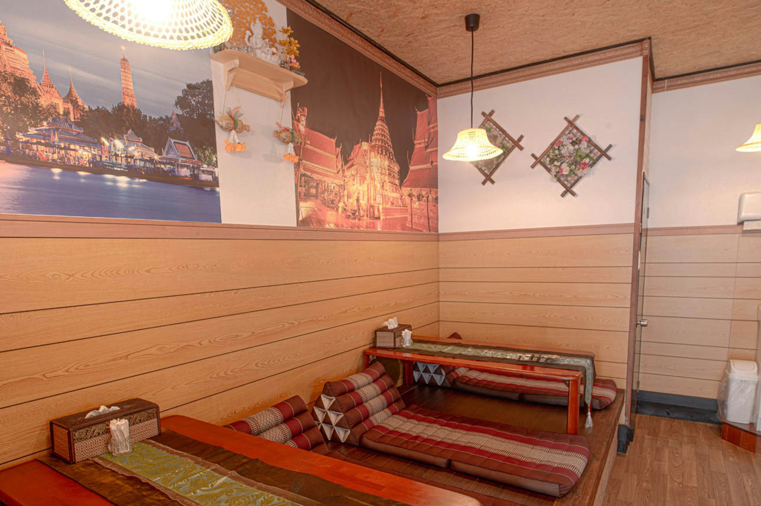 Interior restoran yang terinspirasi Asia yang nyaman dengan seni dinding dan tempat duduk tradisional