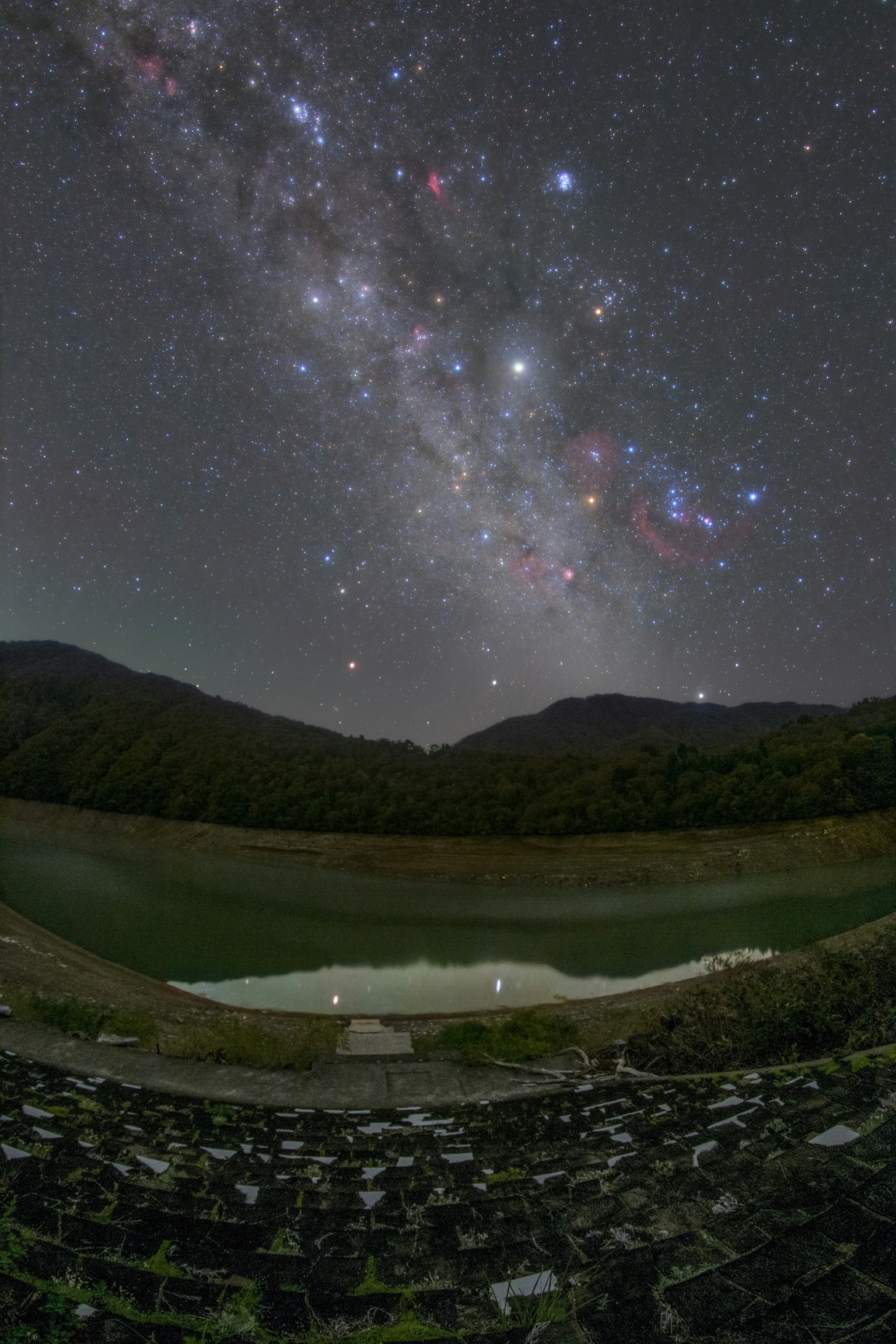 Langit malam dengan bintang dan gunung yang terpantul di sungai