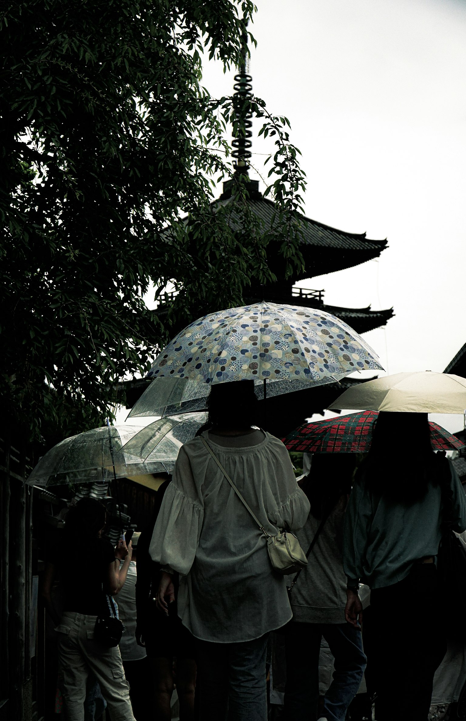 人们拿着伞在古老建筑附近行走