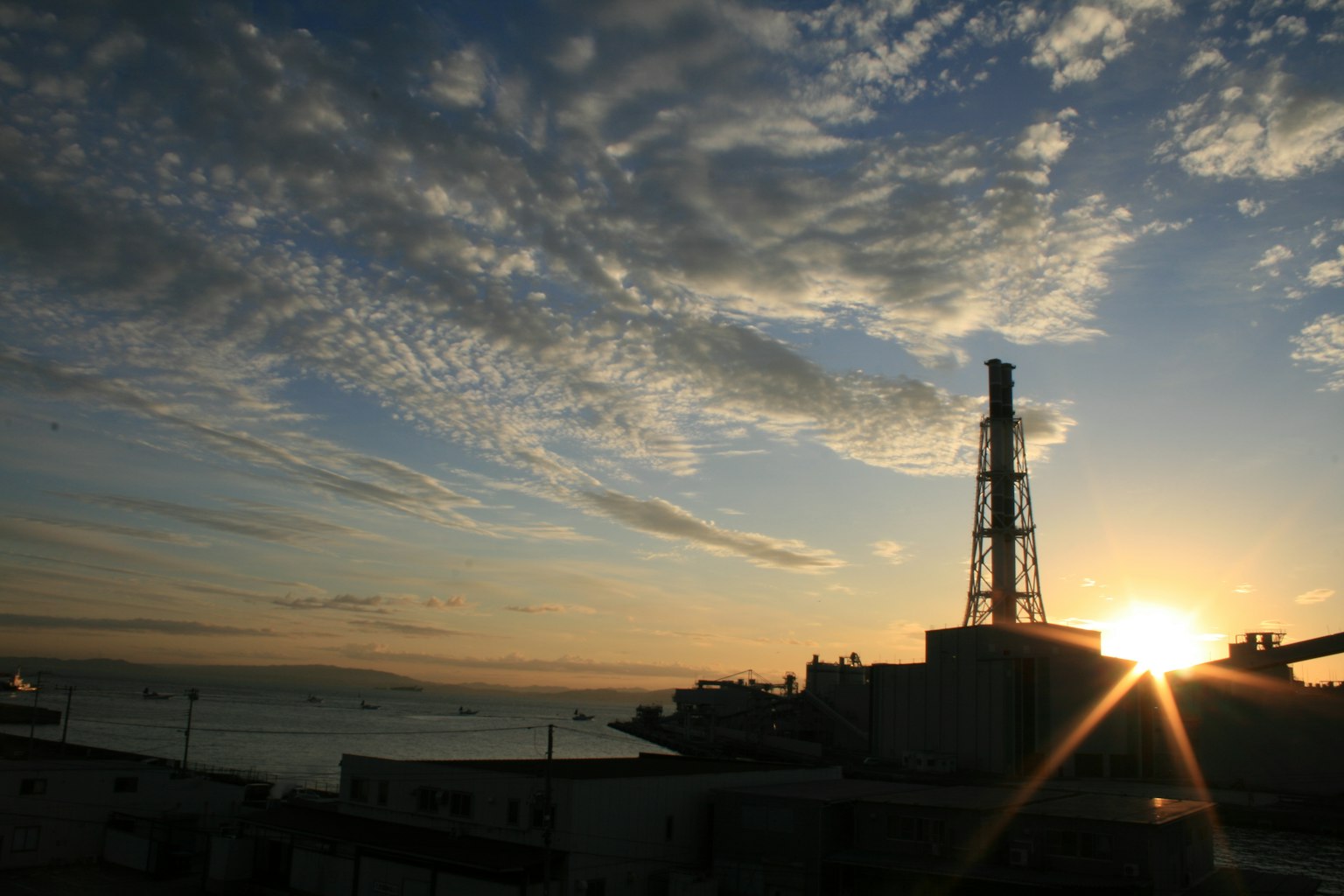 Estructura industrial con un atardecer y cielo nublado