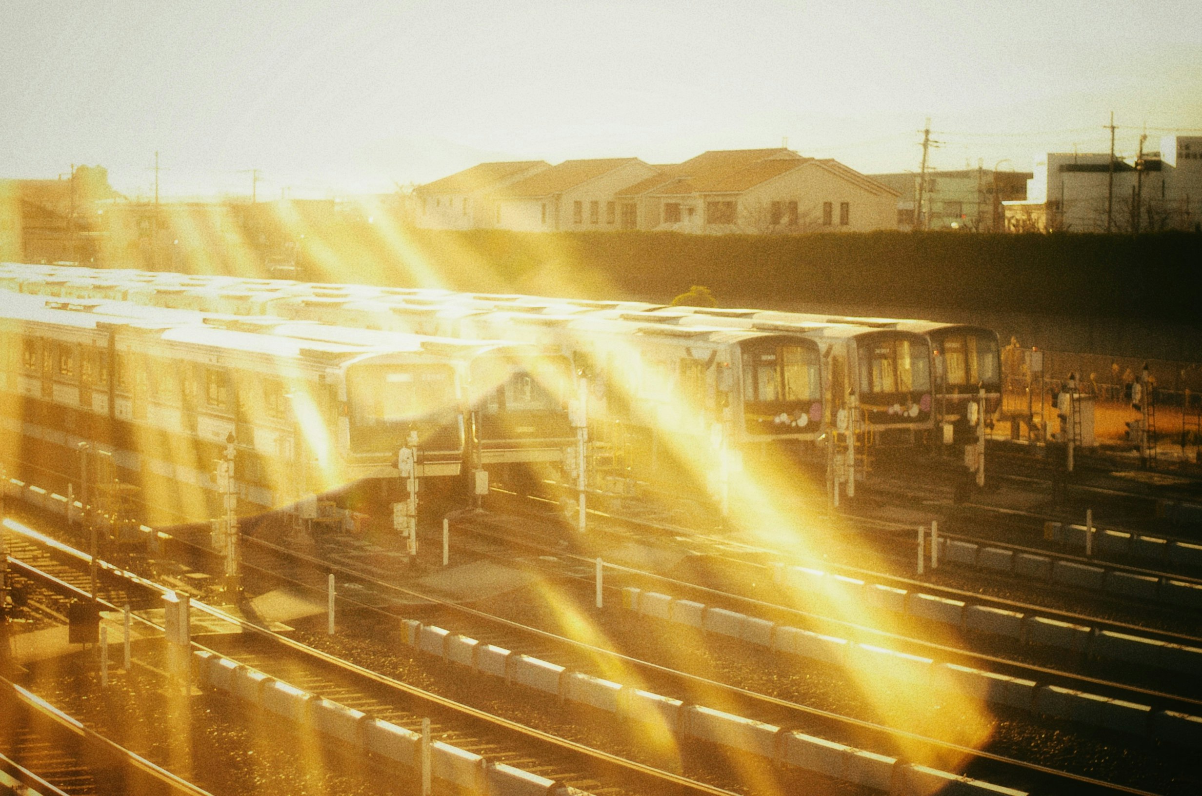夕暮れの駅ホームを走る列車の光跡