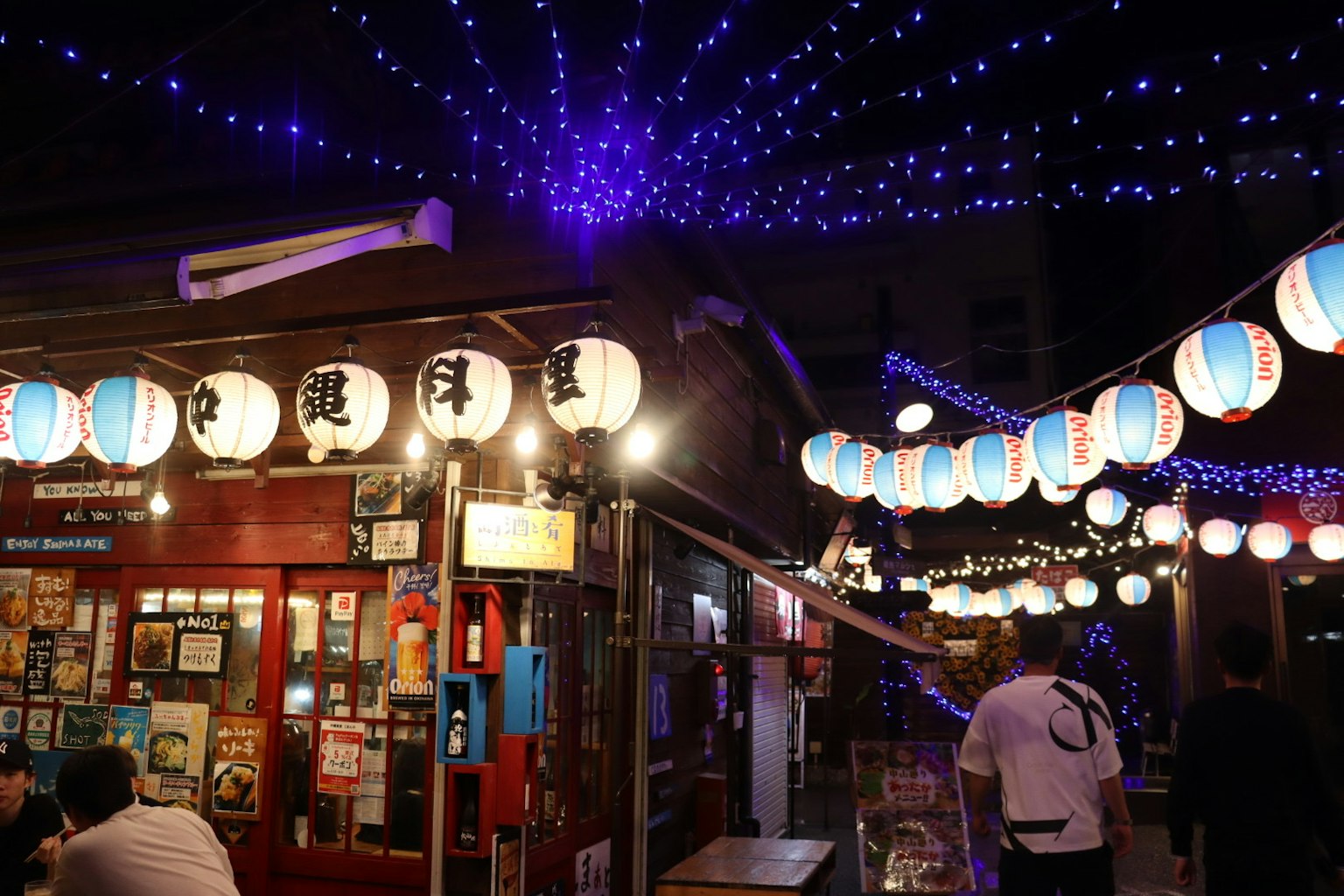 Nachtmarktstraße dekoriert mit Laternen und blauen sternförmigen Lichtern