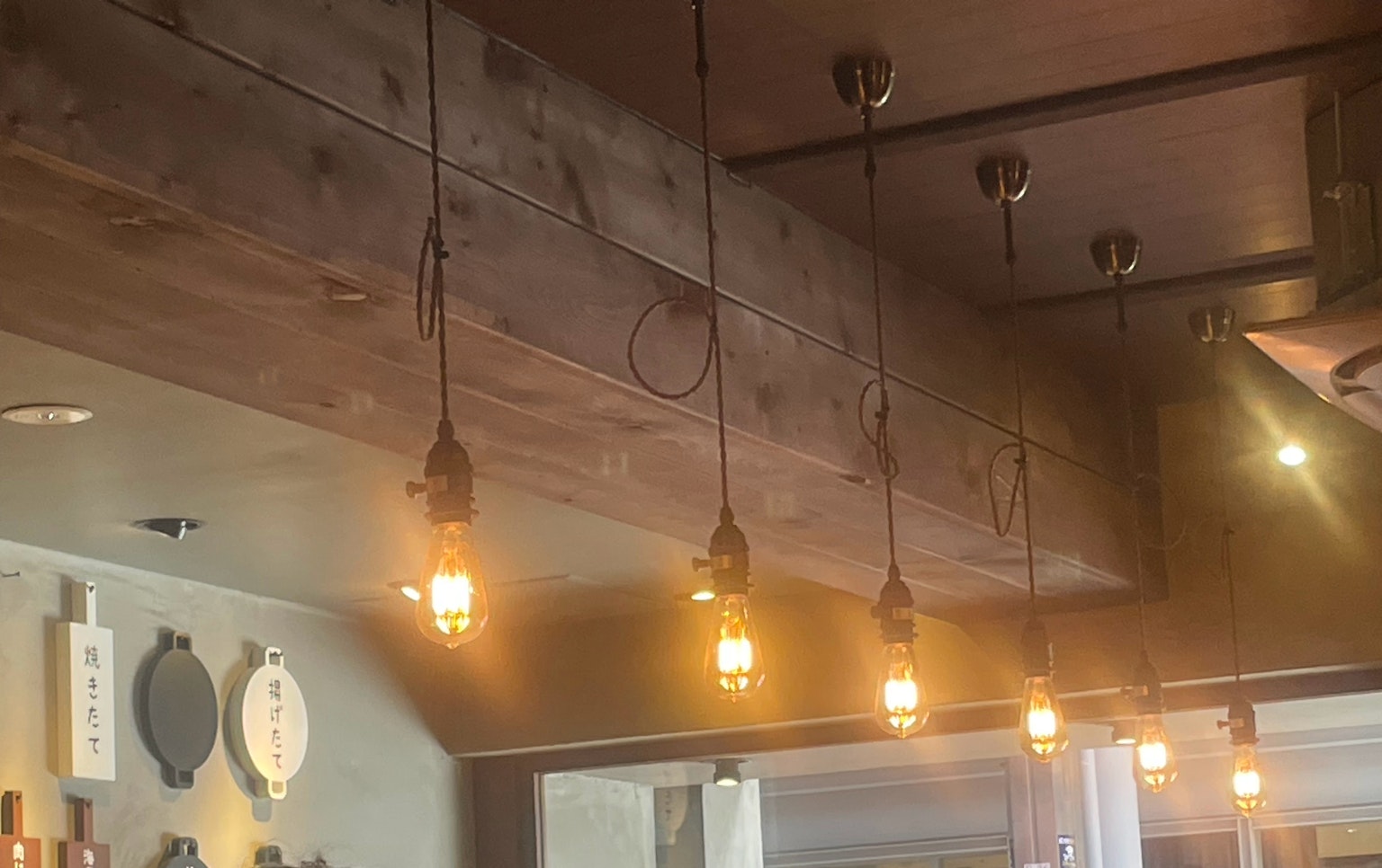 Interno con lampadine calde appese a una trave di legno