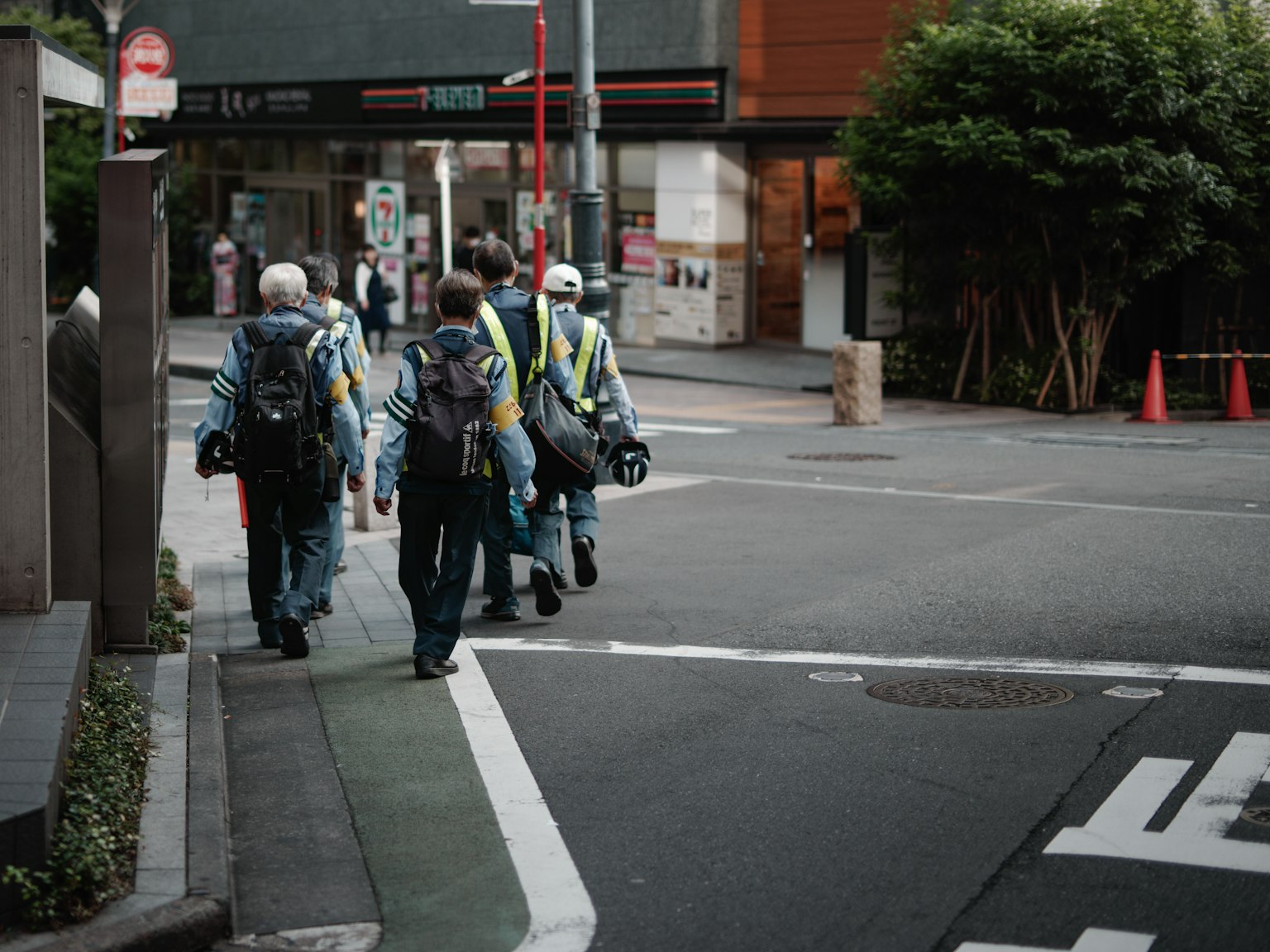 Nhóm công nhân đi bộ trên đường mặc trang phục an toàn và mang ba lô