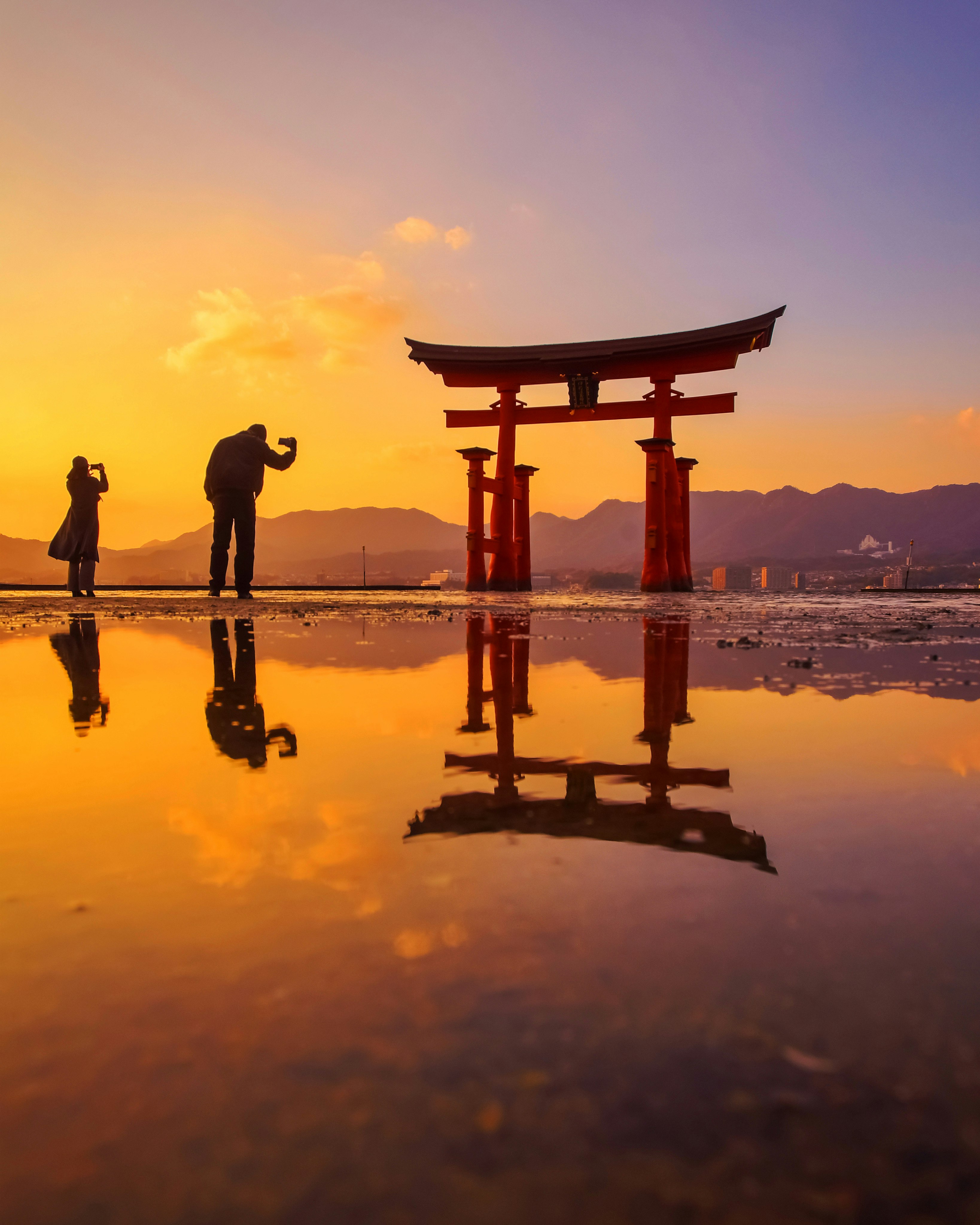 宮島の厳島神社大鳥居と潮の引いた海面の夕景