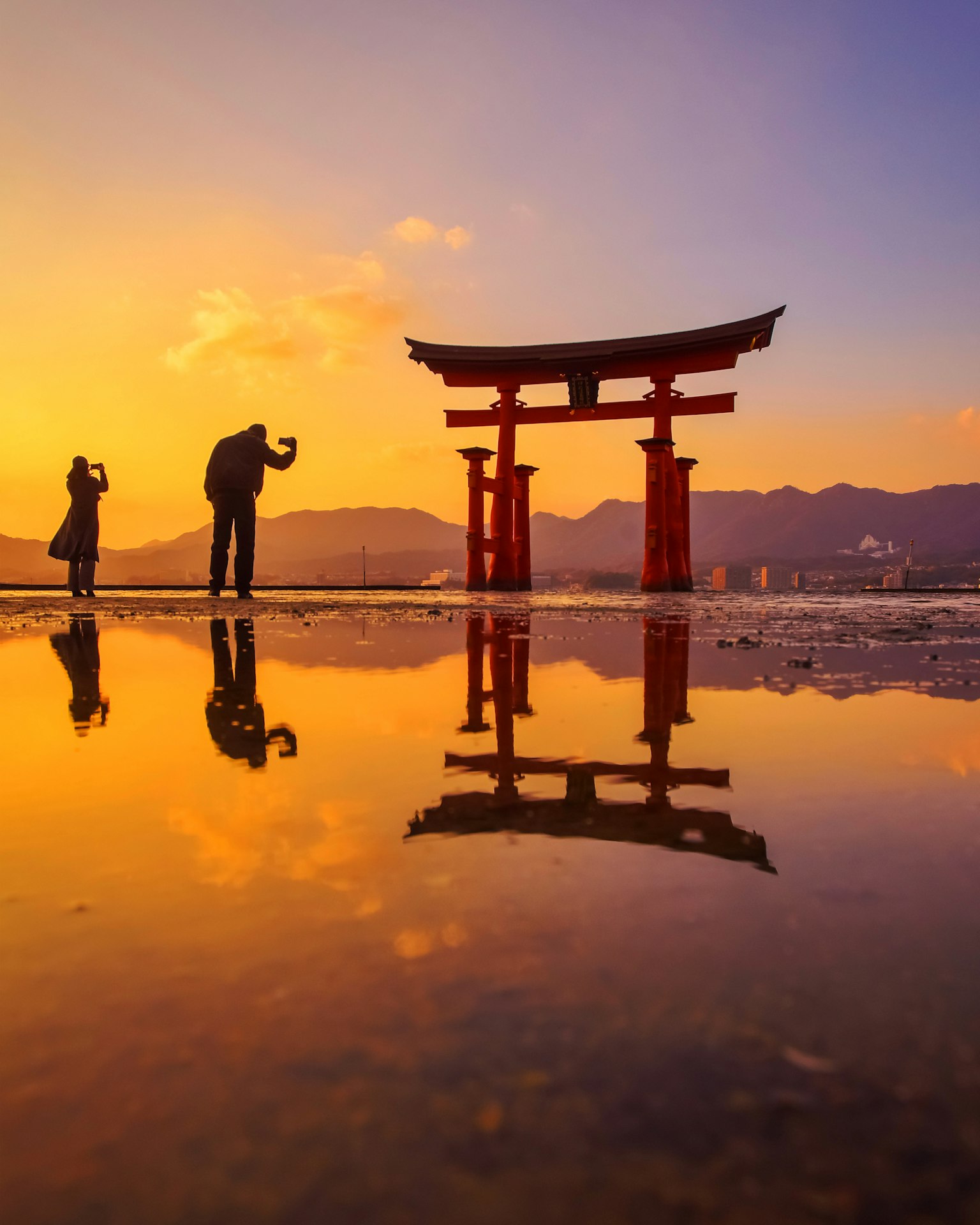 Silhouette di un torii al tramonto con riflessi