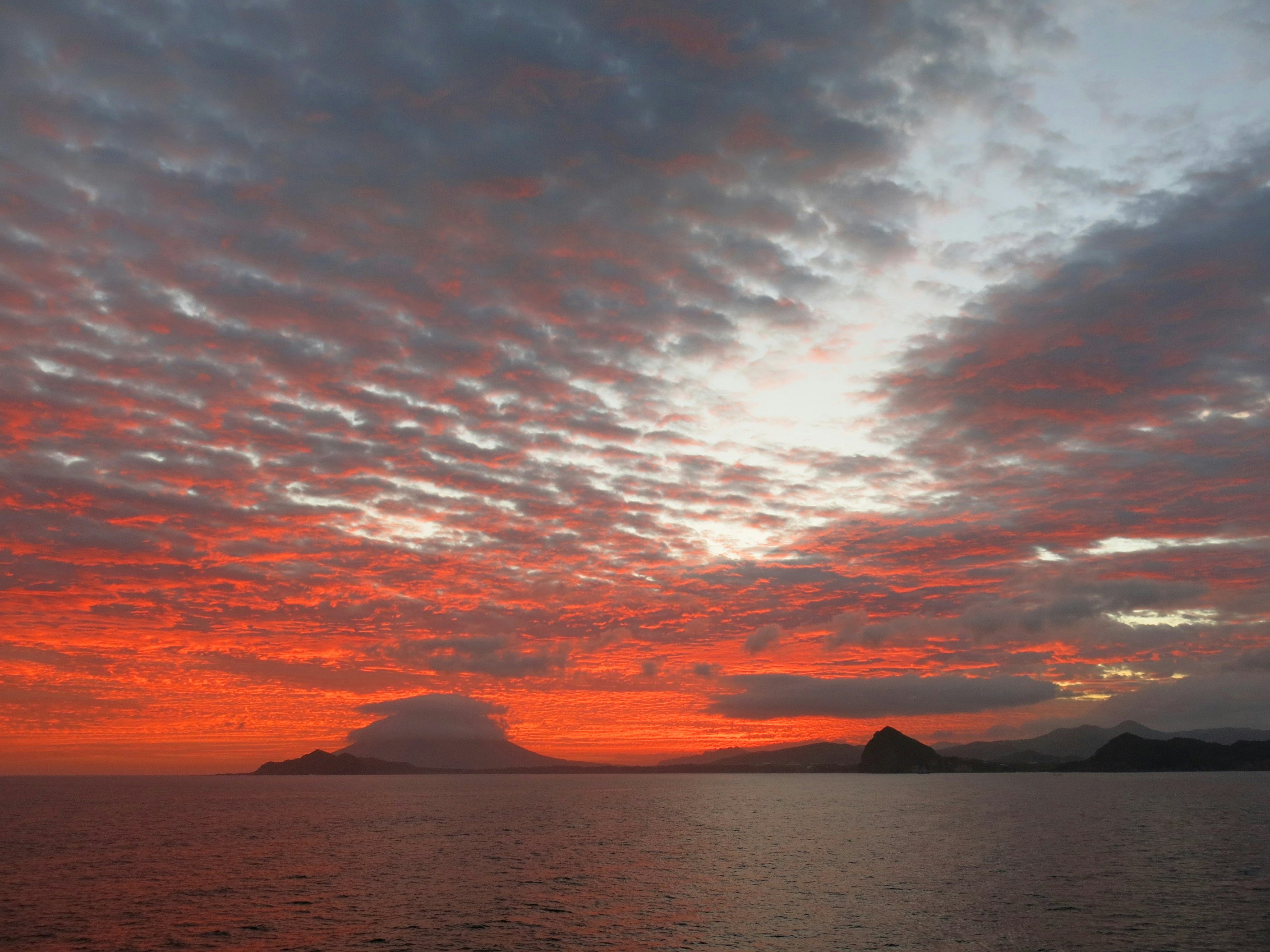 海面日落與地平線上的小島剪影