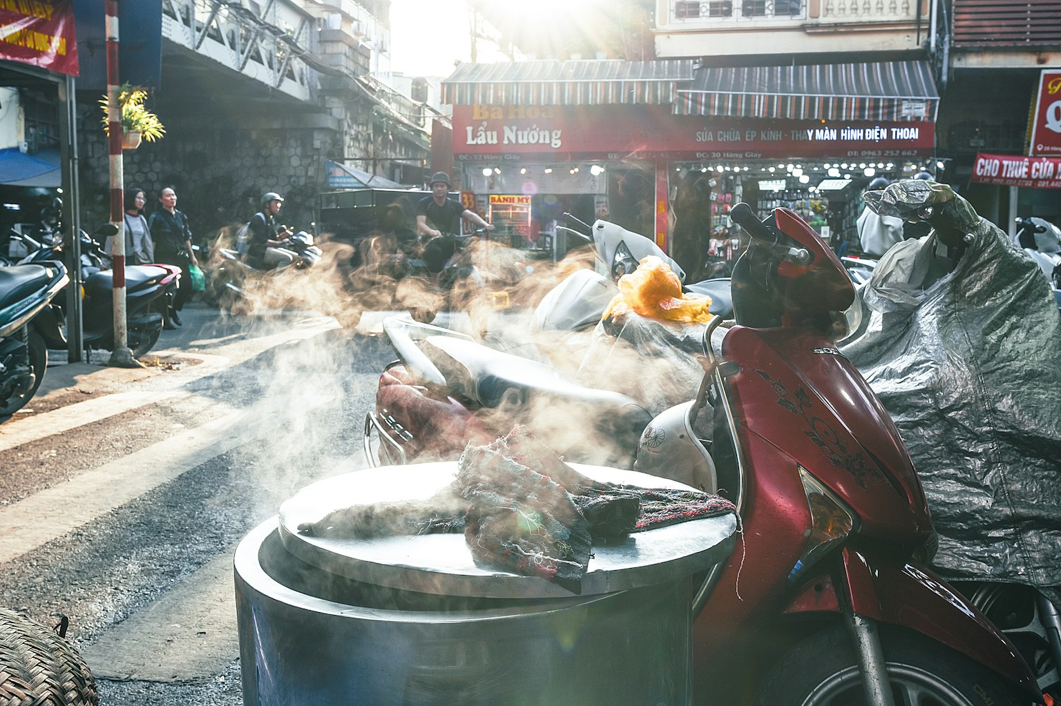 Cảnh chợ đường phố với xe máy và thực phẩm bốc khói